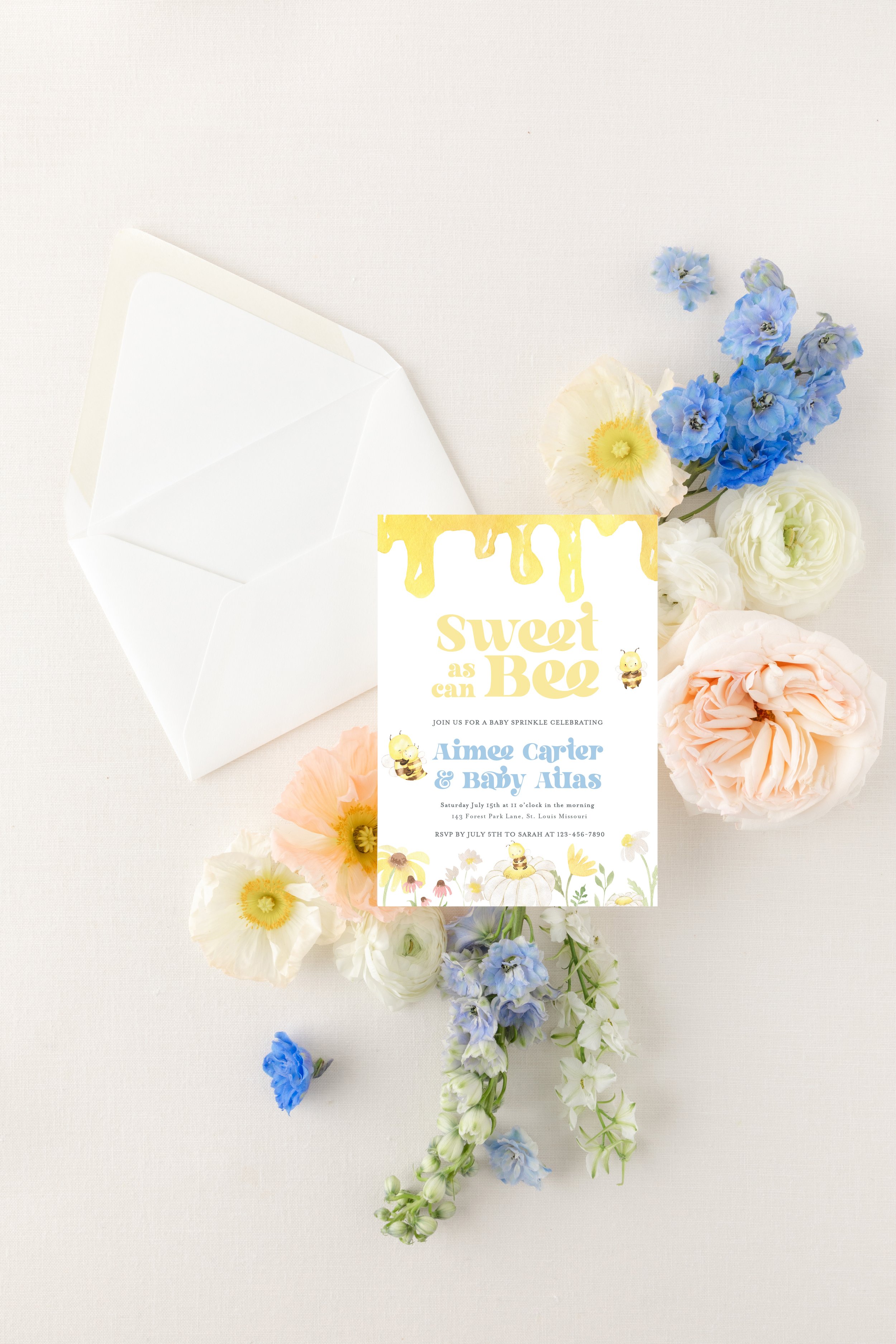 Invitation to a baby shower with pastel flowers and a white envelope on a white background.