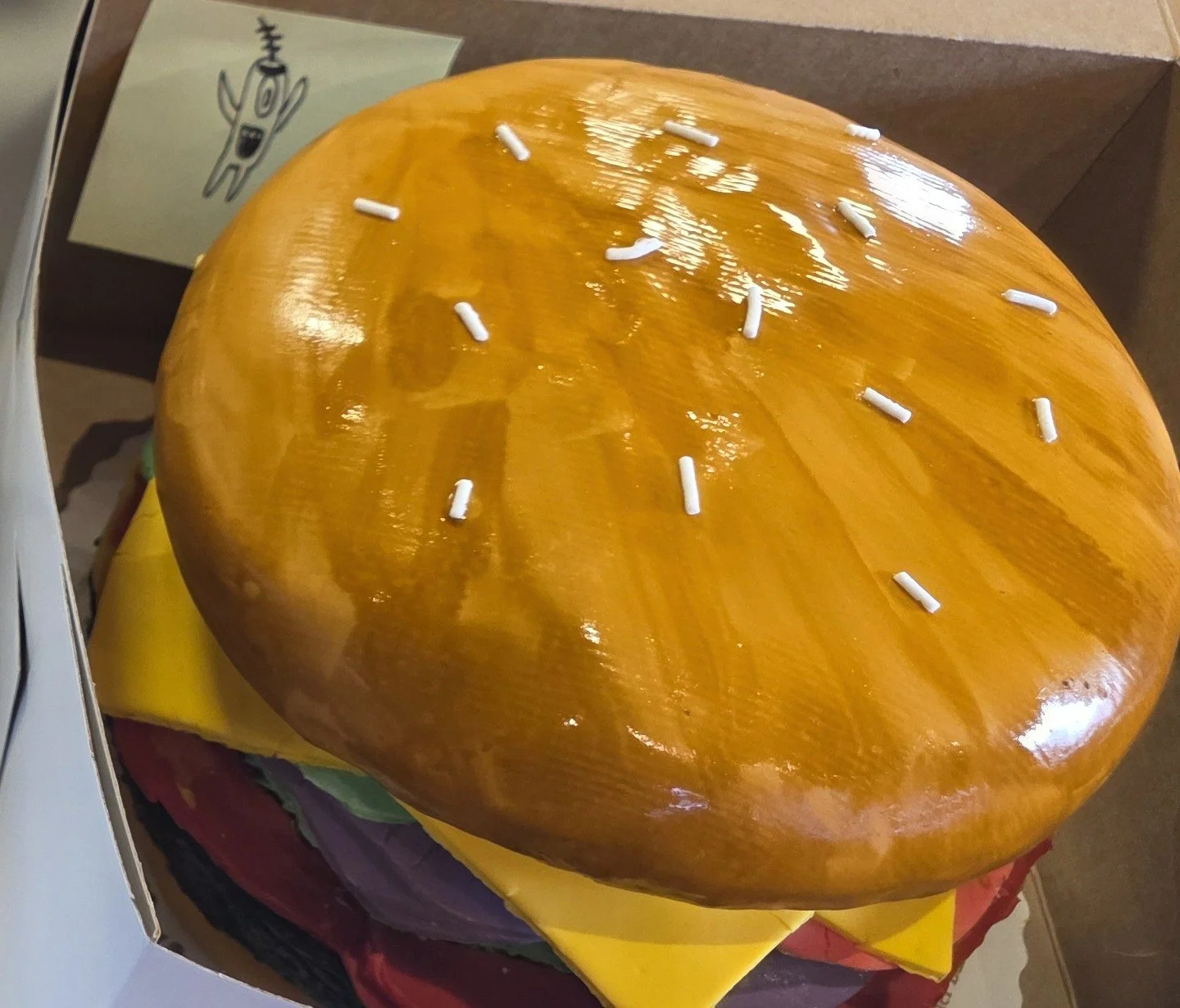 A playful burger-shaped celebration cake made by Jess.