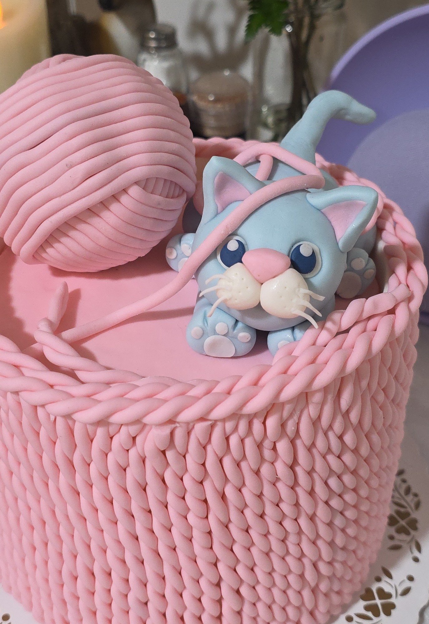 A pink basket cake with a ball of yarn and tiny kitten, made by Jess.