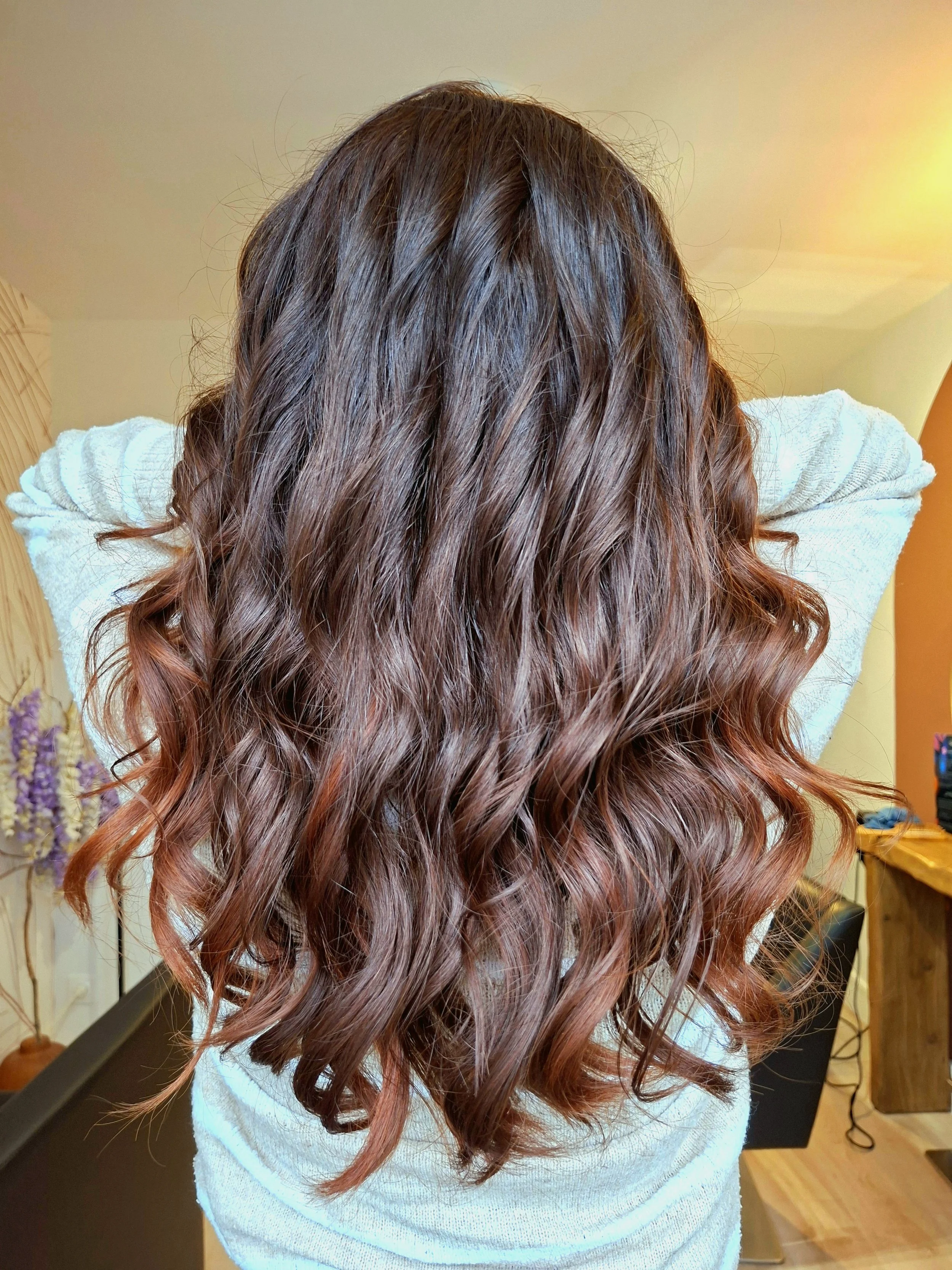Cheveux longs, ondulés, brun cuivré, avec des reflets rouges
