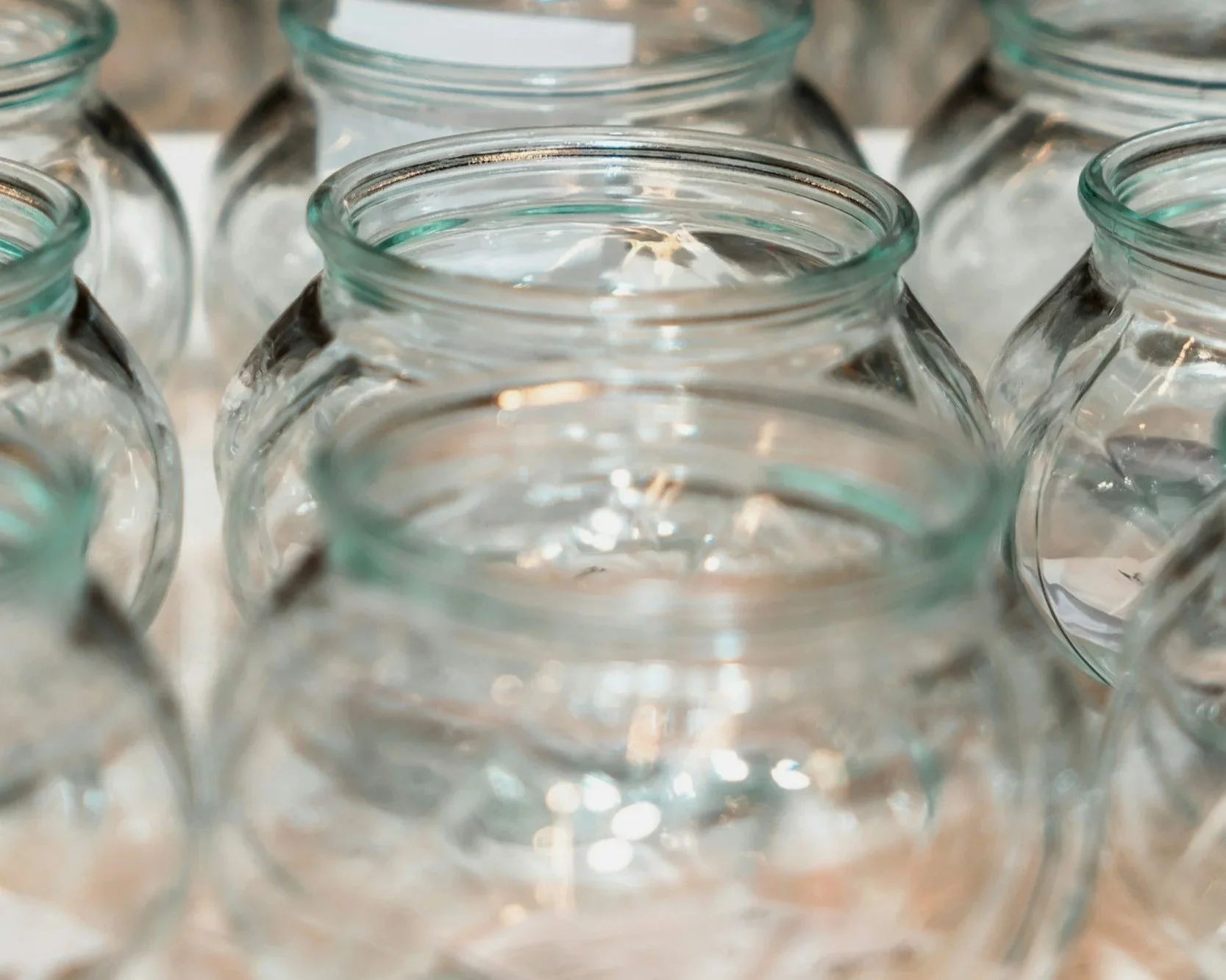 Close-up of multiple empty glass jars arranged closely together.