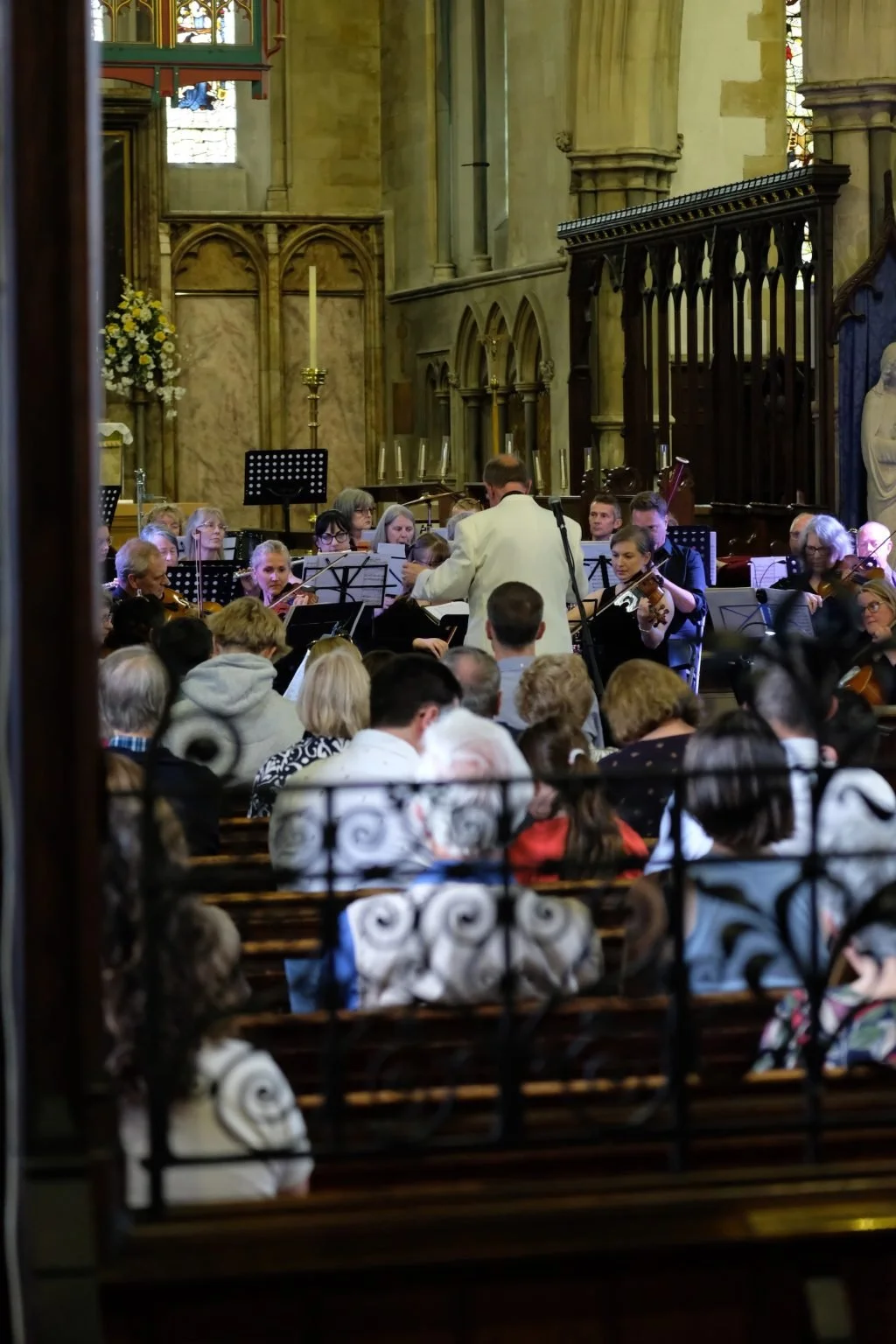Orchestra performing in a church with audience watching.