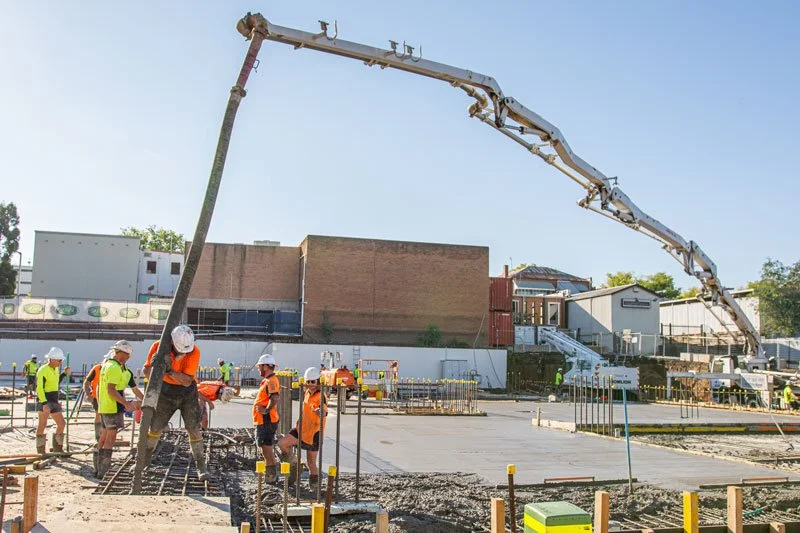 concrete truck and men pouring concrete
