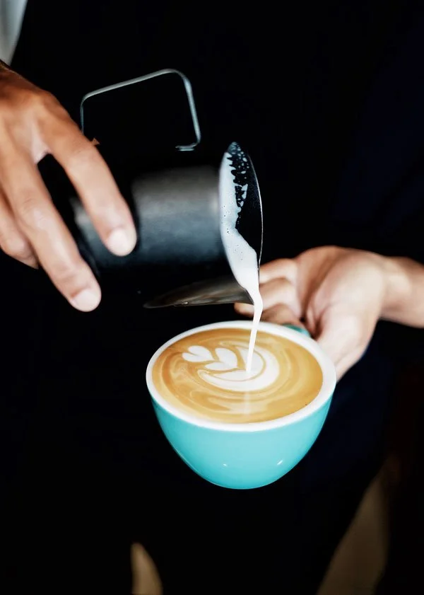 milking pouring from a jug into a coffee cup