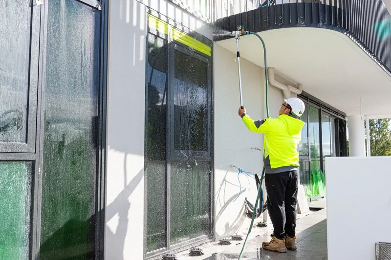 man with pressure hose water tight testing a window