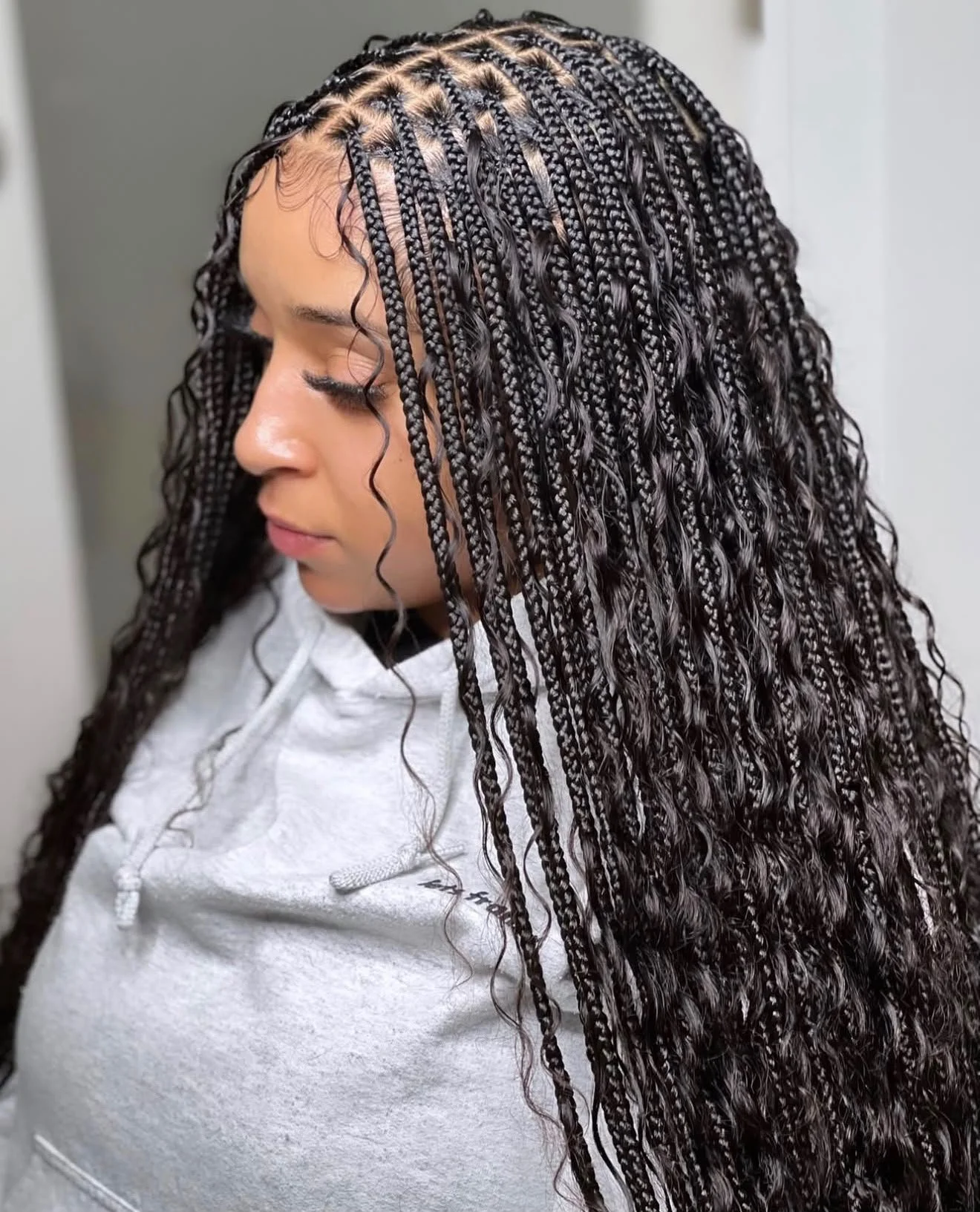 Femme portant de longues tresses africaines noires ondulées, vue de profil.
