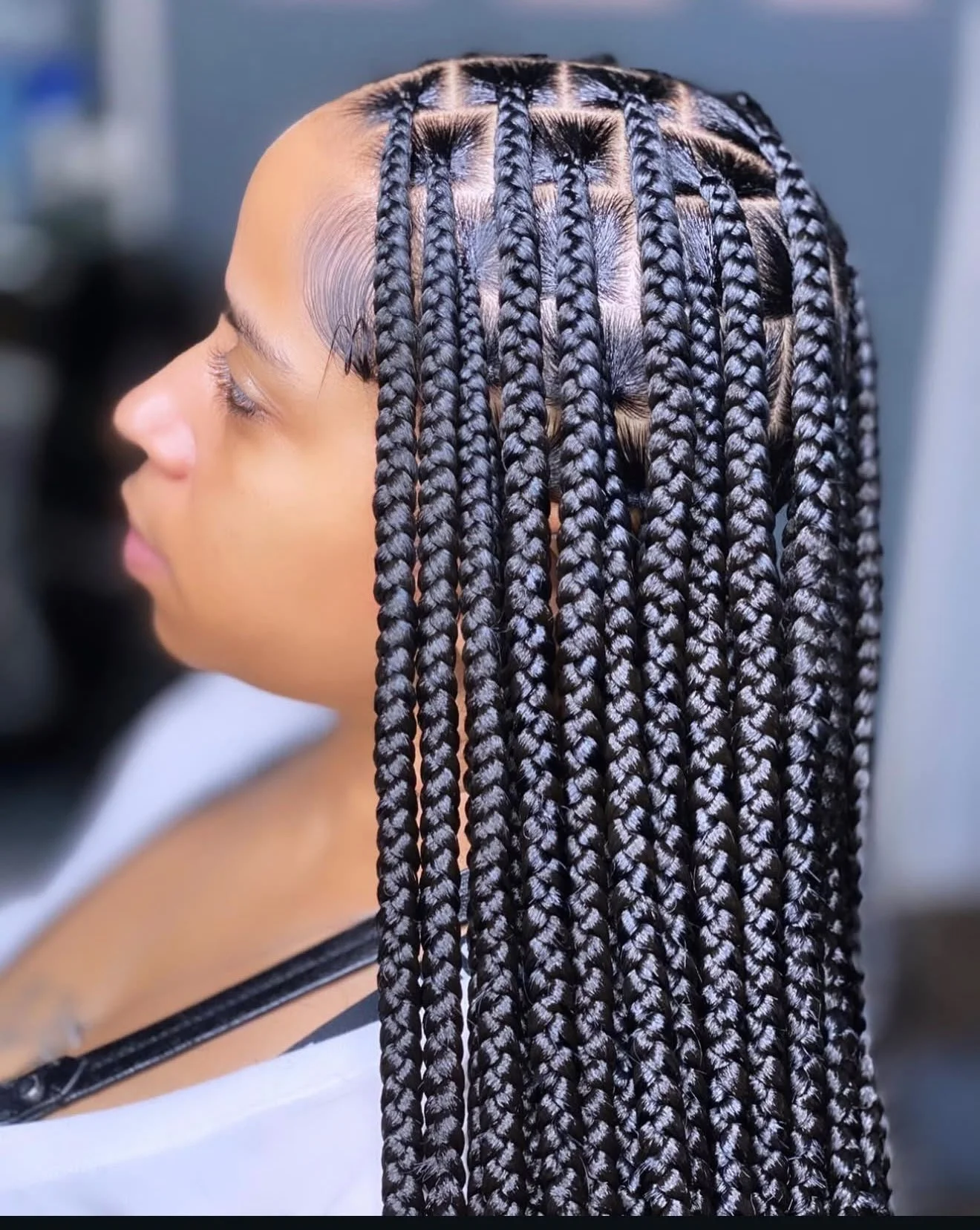 Profil d’une personne portant de longues tresses africaines noires soigneusement séparées en carrés.