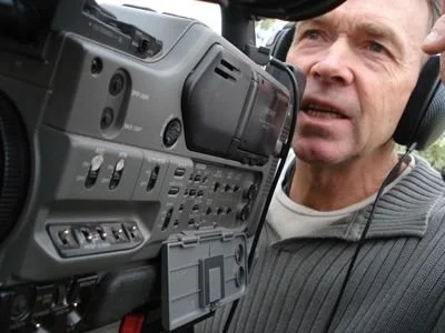 Man speaking into a professional video camera
