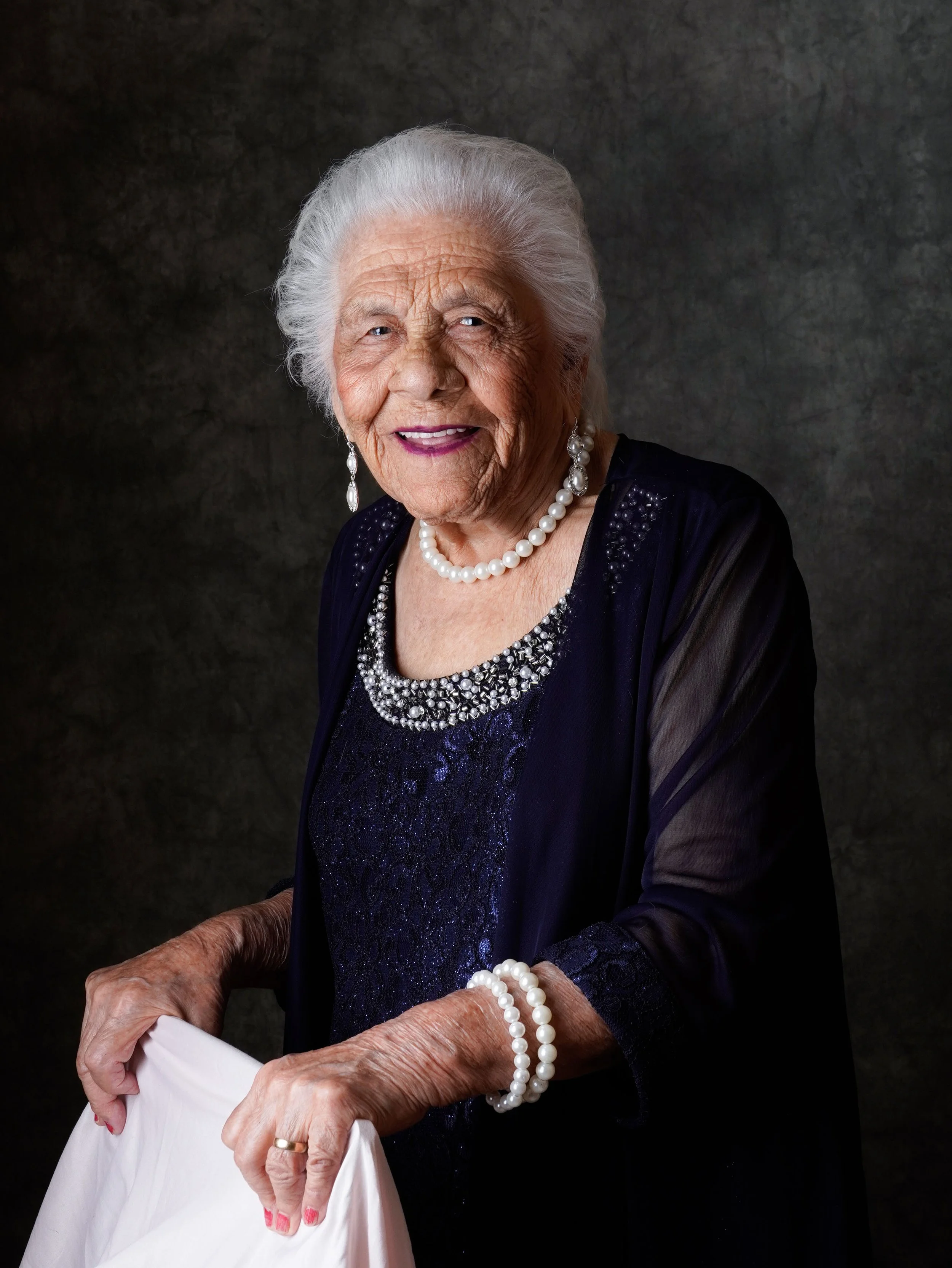 elder lady posing behind a chair