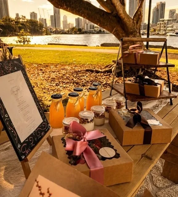 Catering gift boxes and juices on a picnic table by the river, Gold Coast