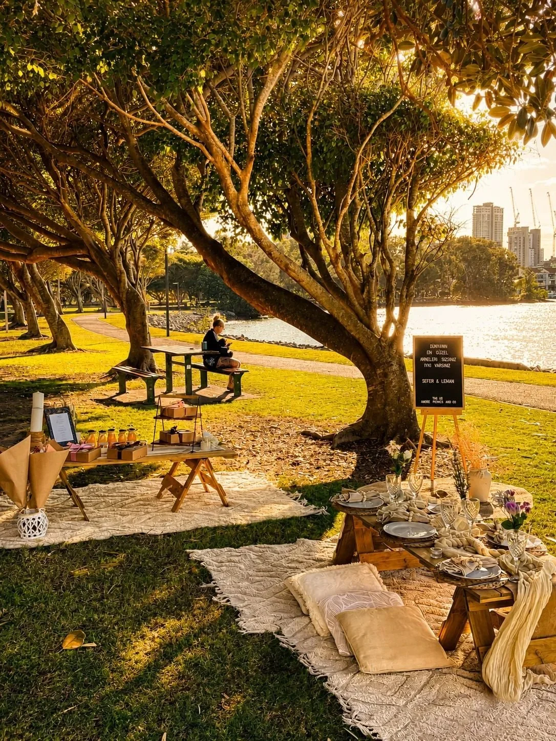 Golden hour pop-up picnic under the trees by the water, Gold Coast