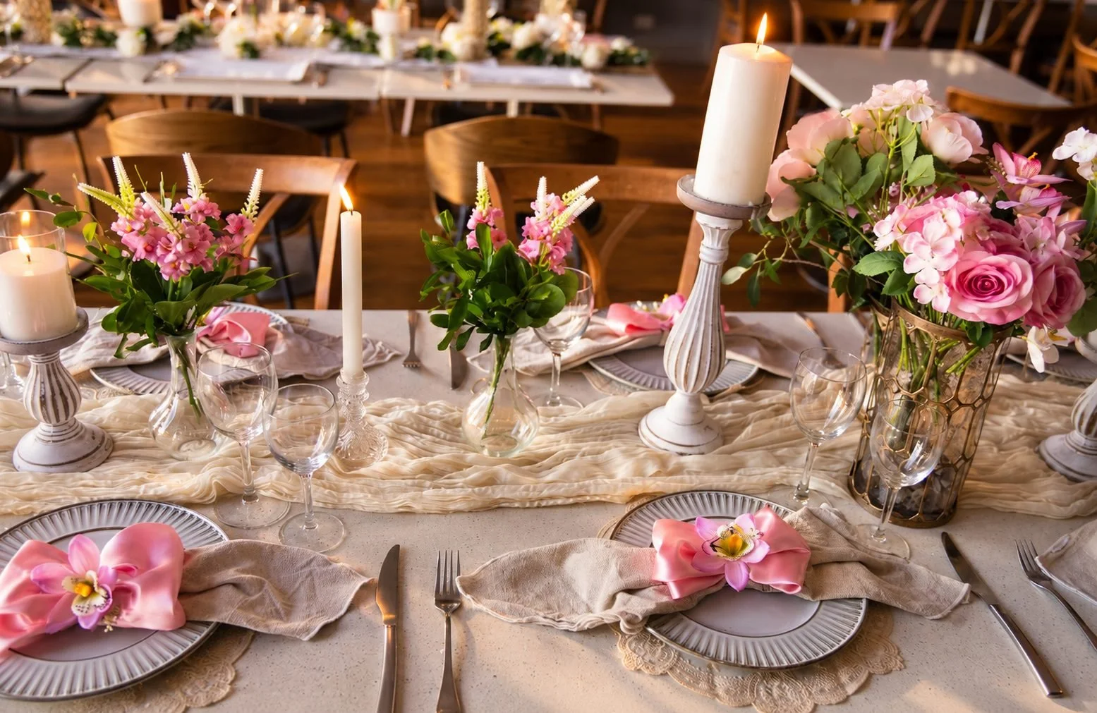 Candlelit event table with pink napkins and rose arrangements, Gold Coast