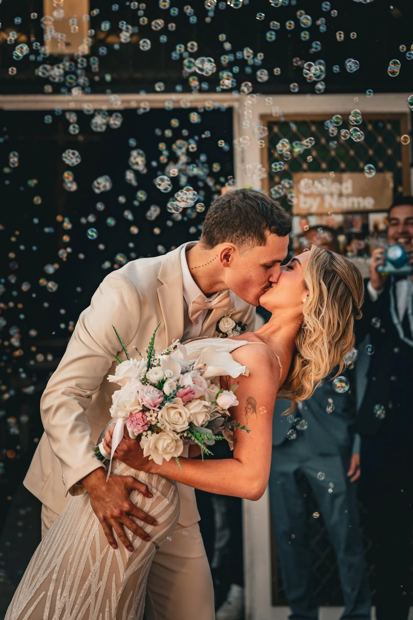 Couple kissing among floating bubbles at an intimate wedding celebration styled by Amorè Picnics & Co., Gold Coast