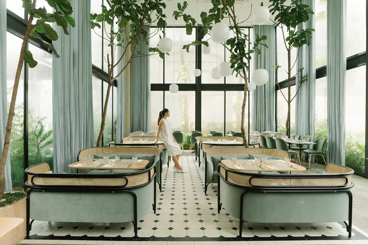 GamFratesi have taken the inspiration of a light filled glasshouse whilst maintaining contact with tropical nature in a café in Manila. The concept breaks down the boundaries between indoors and outdoors in a busy city setting.