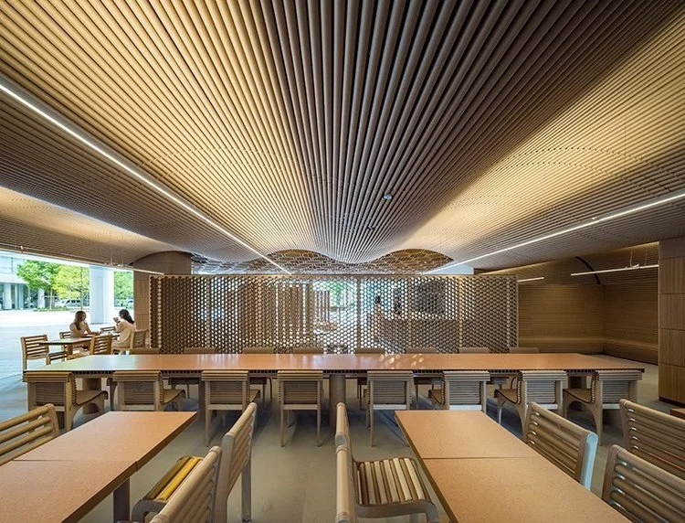 Shigeru Ban Architects use recycled cardboard tubes, for interior design elements such as ceilings, partitions, and chairbacks, along with Richlite, a sustainable material made from paper, for tables and counters.