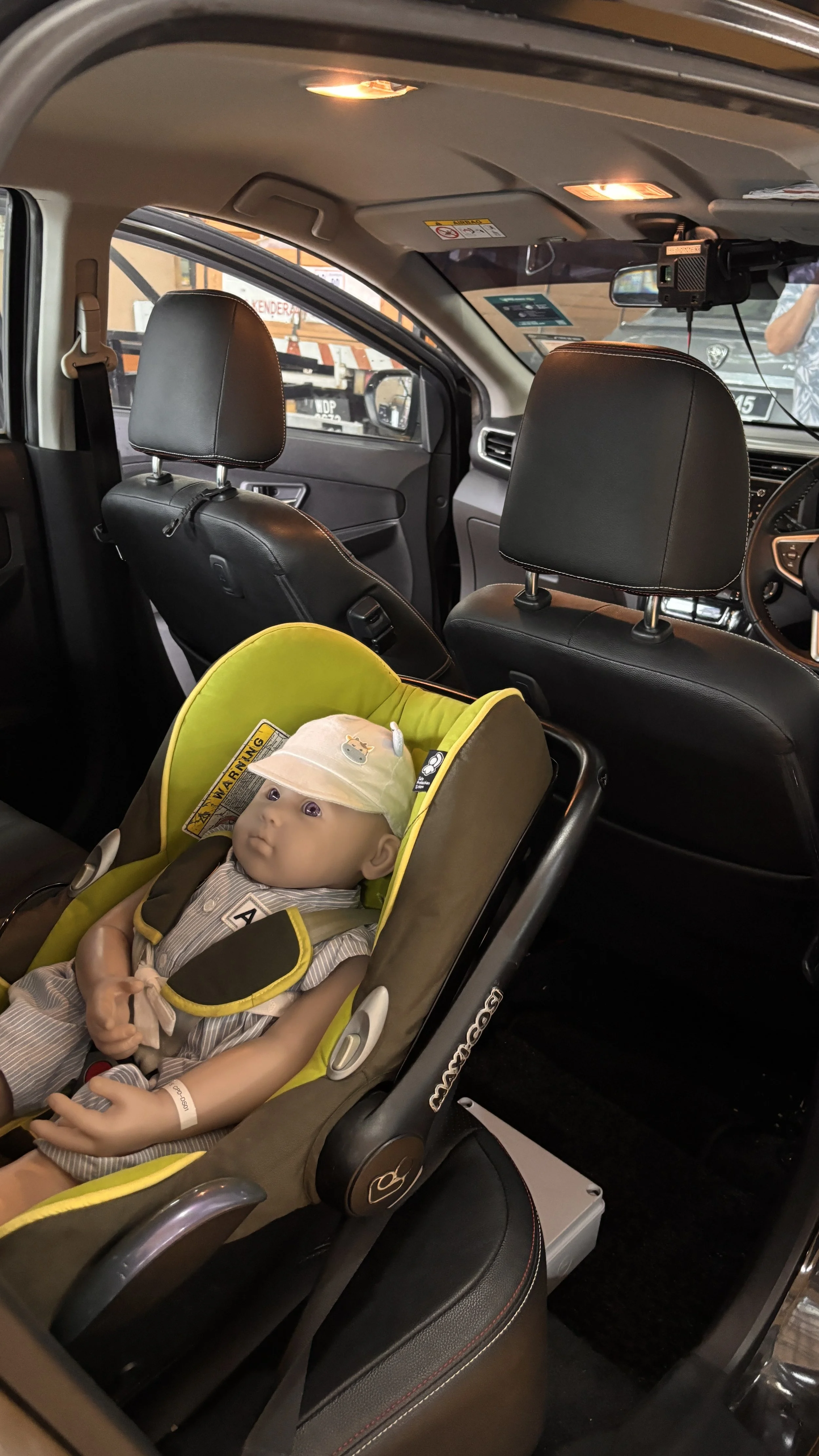 Child Presence Detection (CPD) dummy secured in a rear-facing child restraint system inside a vehicle during the technology assessment of SafeSync360, a next-generation infotainment system with Child Guard Technology developed by UTP–BETAMEK.