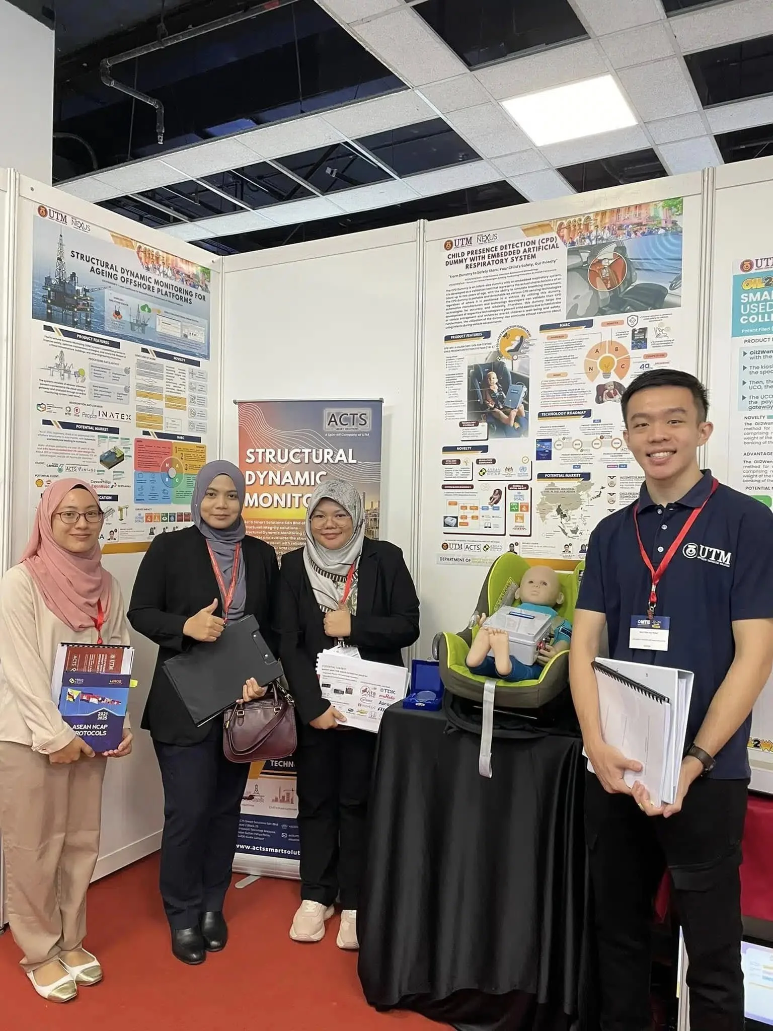 UTM–ACTS representatives showcasing the CPD-DS1 Dummy and structural monitoring innovations at Malaysia Technology Expo 2024.