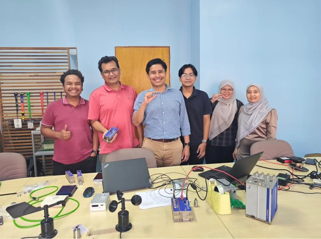 Group photo of UTM, ACTS, and INVICOM representatives alongside structural monitoring instrumentation and data acquisition equipment.