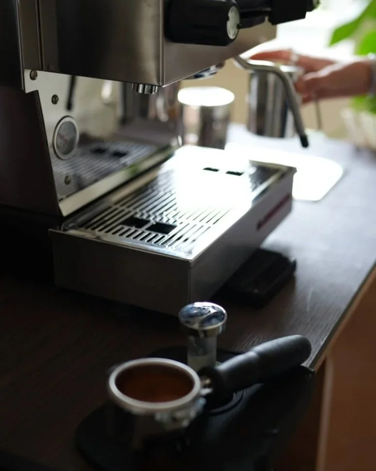 Espresso machine, portafilter and milk pitcher arranged on a countertop