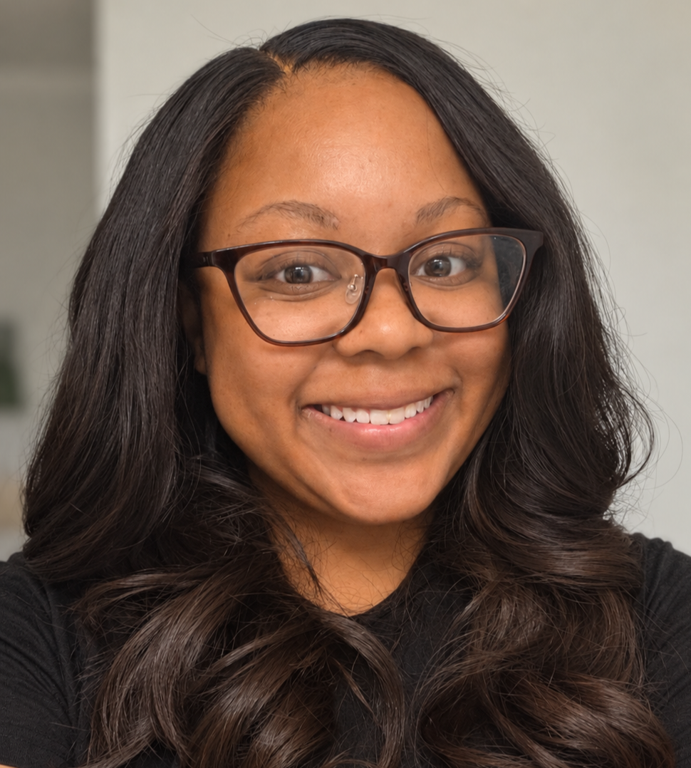 Smiling woman with long dark hair and eyeglasses posing for a close-up portrait