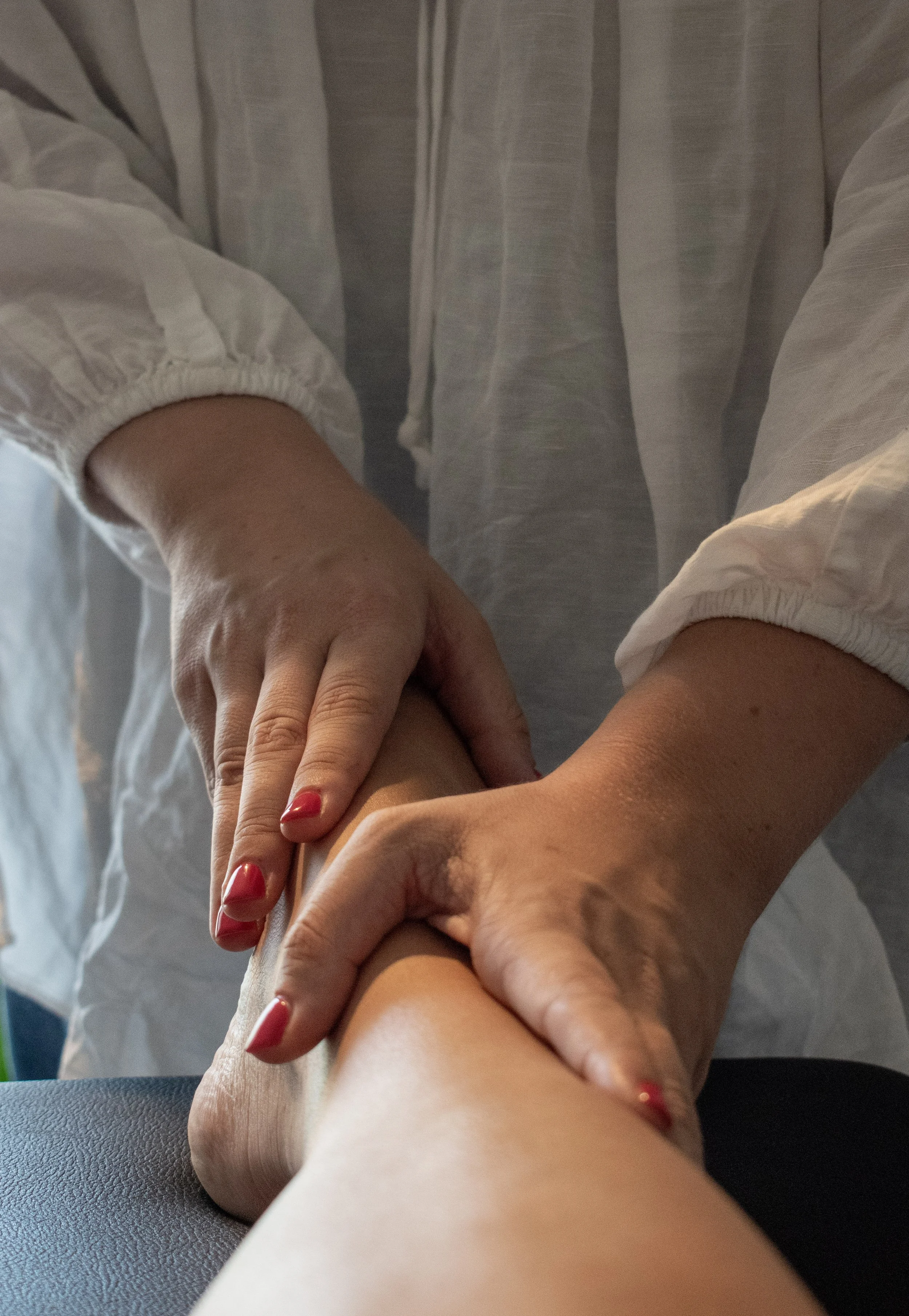 Gros plan sur les mains d’un professionnel de santé examinant le poignet d’une personne âgée.