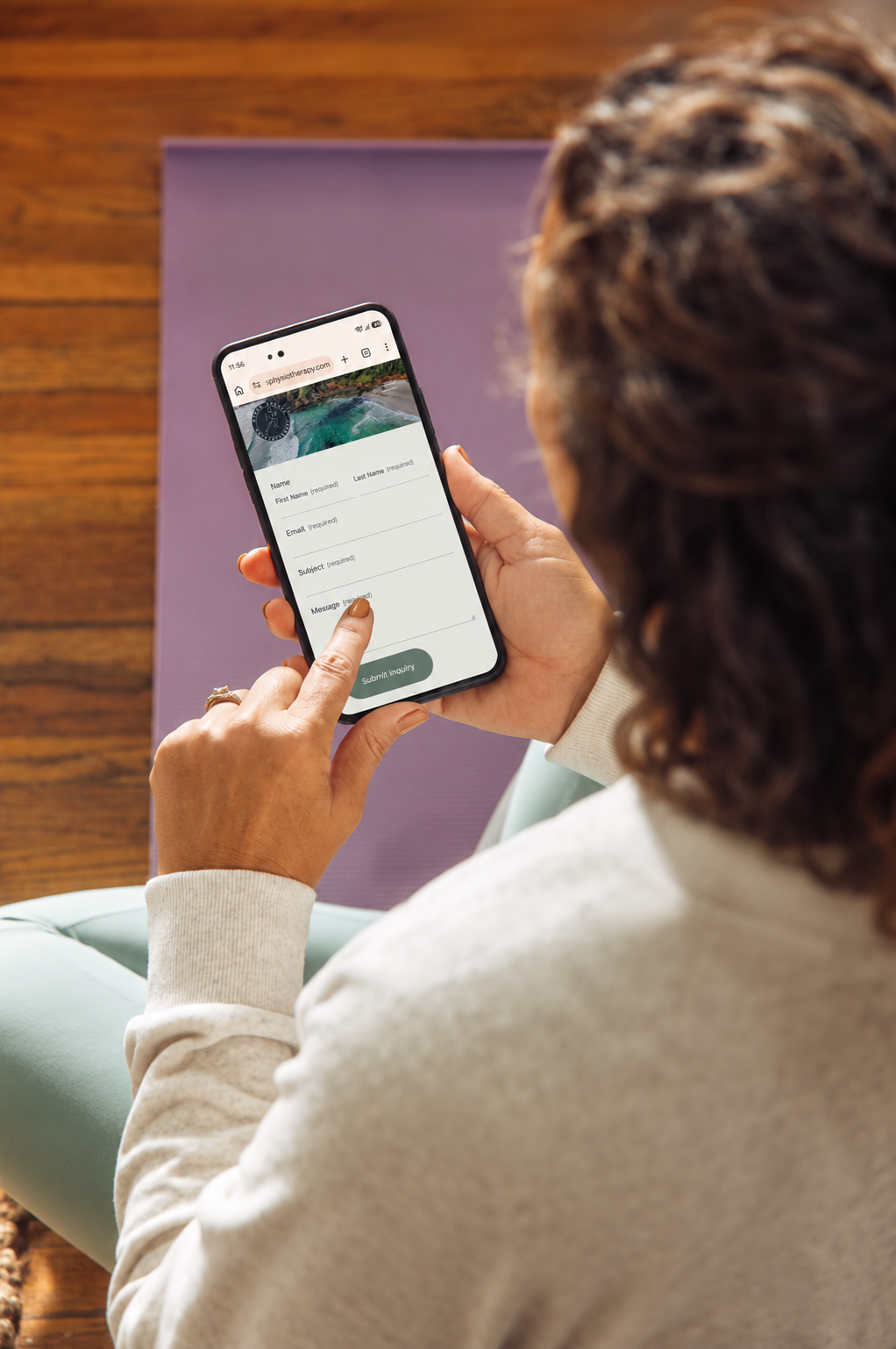 Woman pacient using a smartphone to complete an online contact form to book in a Telehealth appointment