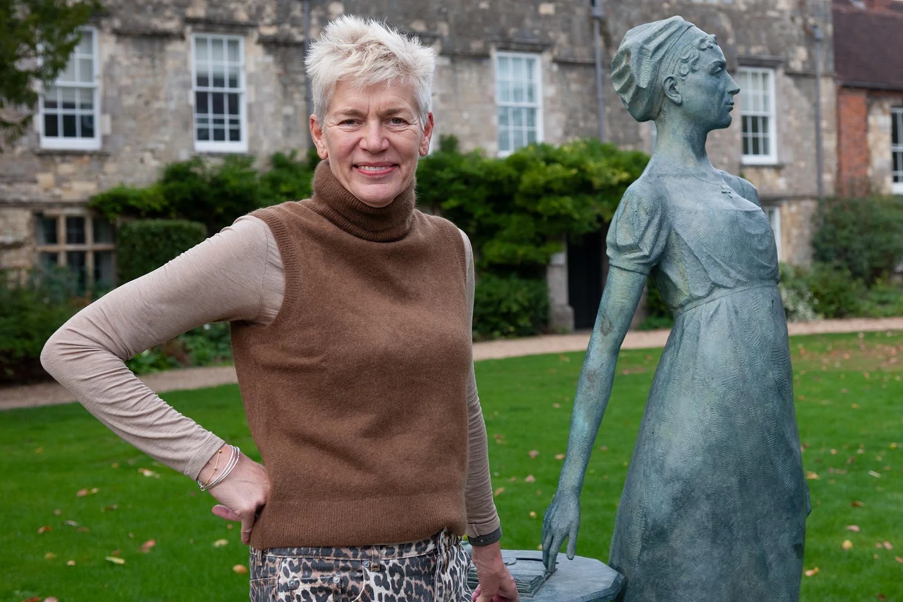 Dr Michelle Lowe beside a bronze statue in a Winchester garden