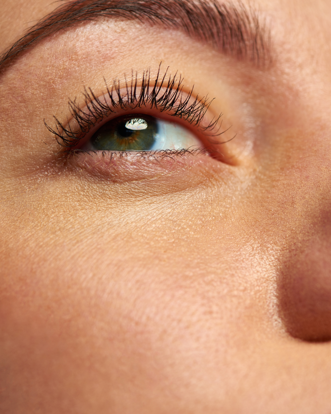 Close-up of a woman's eye and smooth under-eye skin