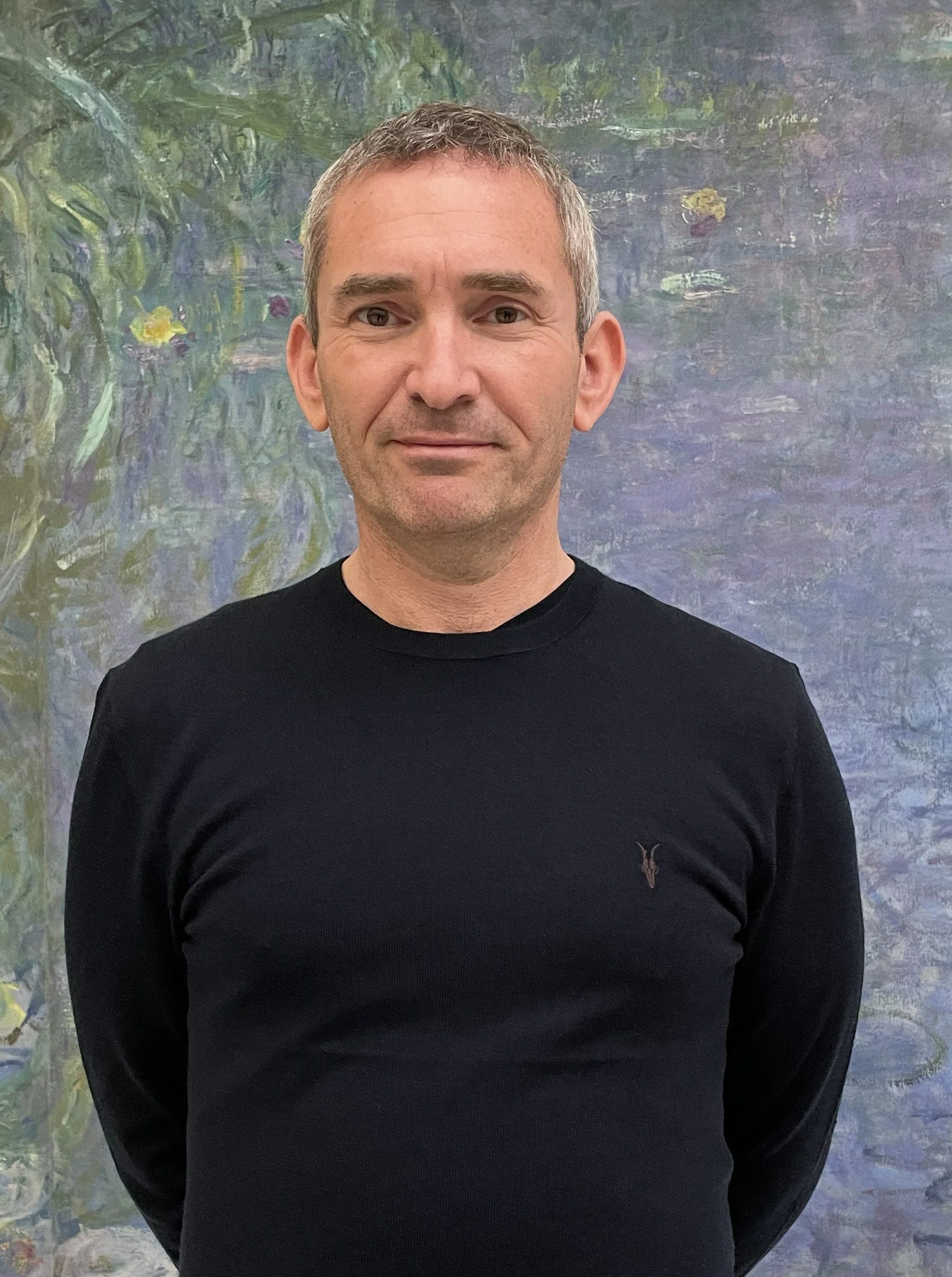 portrait photo of the artist justin butler with water lillies background