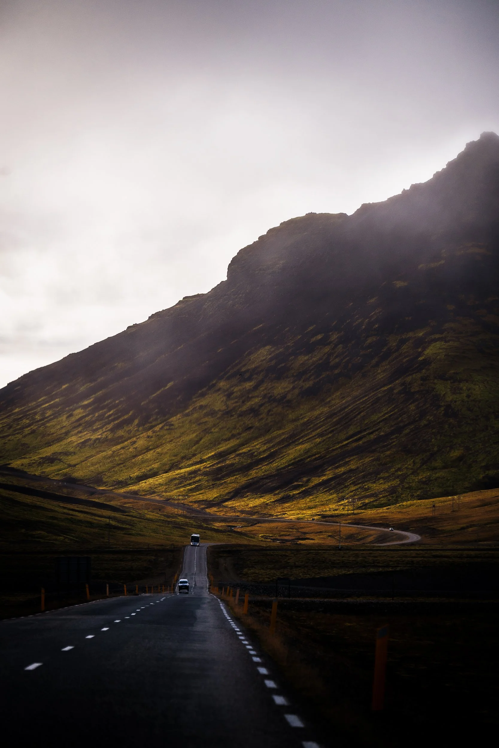 Winding road through a dramatic Icelandic mountain landscape at dusk