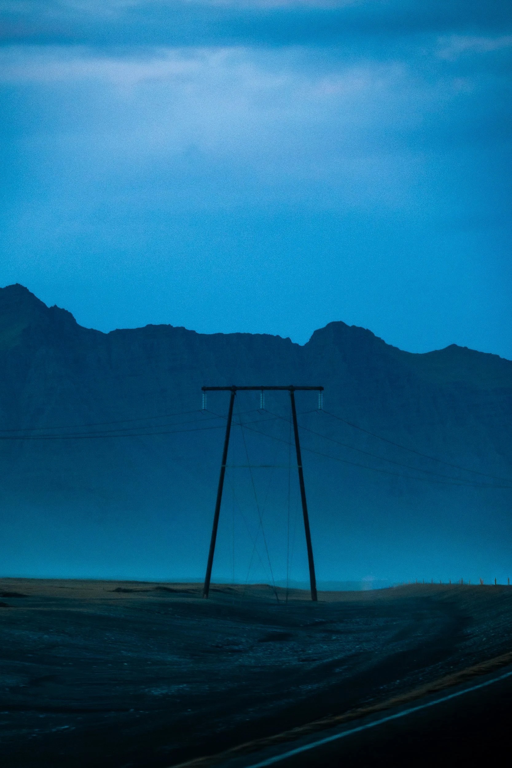 Silhouetted swing set against rugged mountains at dusk