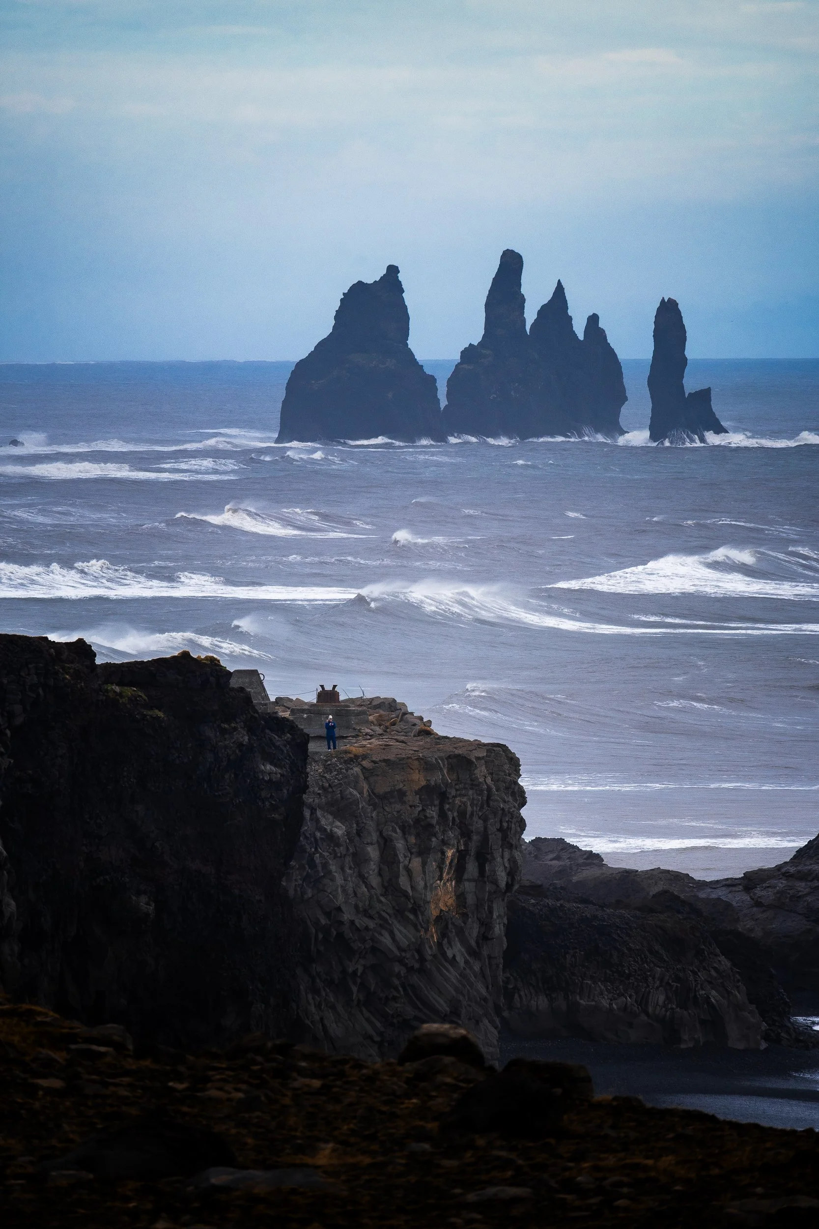 Dramatic basalt sea stacks rising from rough ocean waves along Iceland’s black volcanic coast
