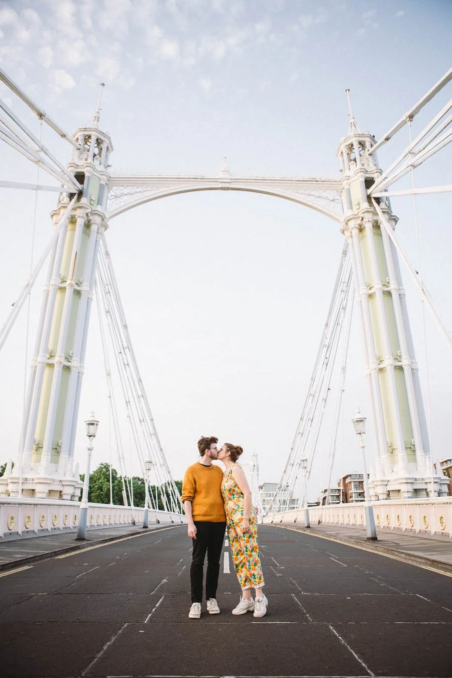 Engaged couple standing in the middle of the The Prince Albert Bridge kissing
