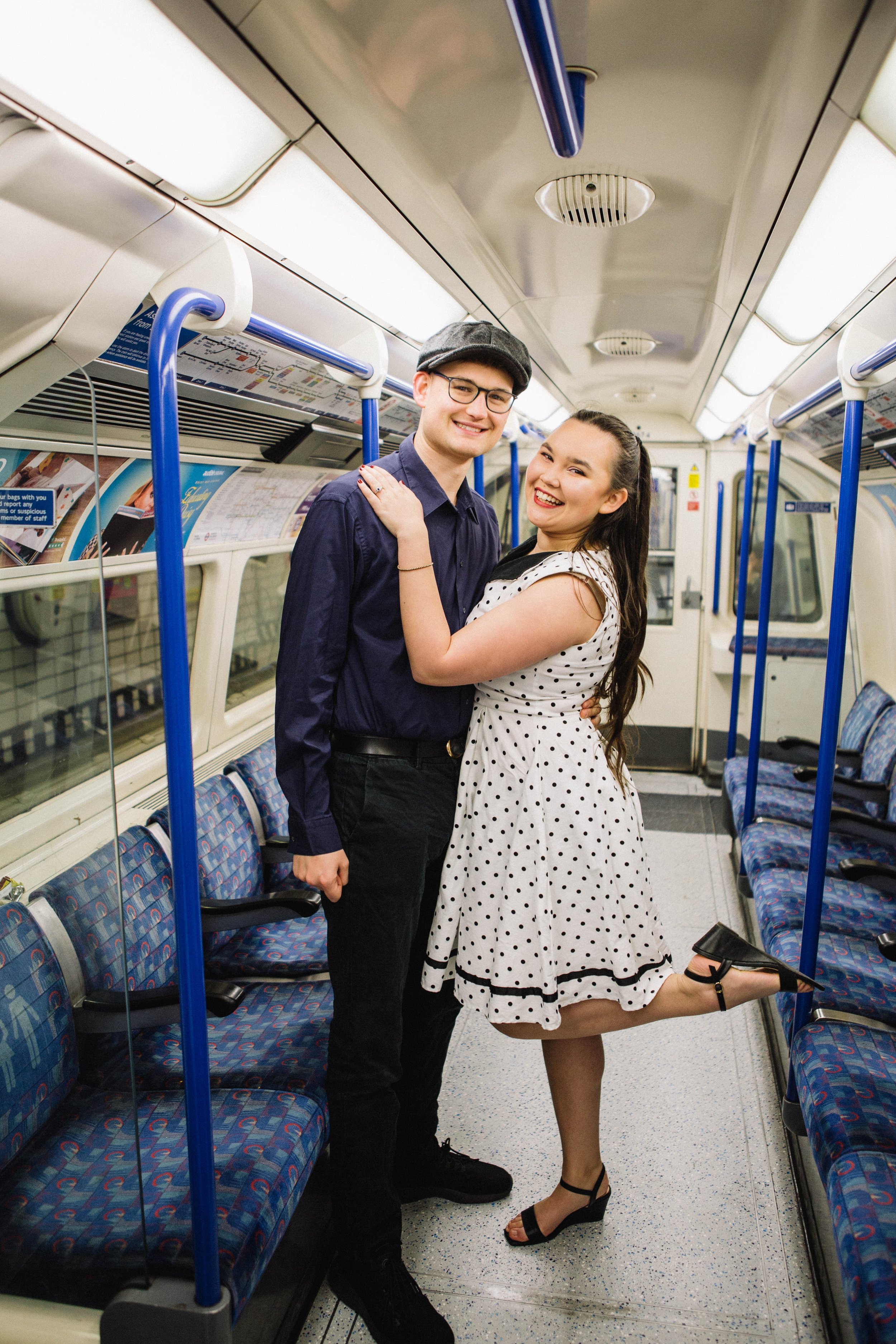 Engaged couple smiling on the tube during their pre-wedding photography session