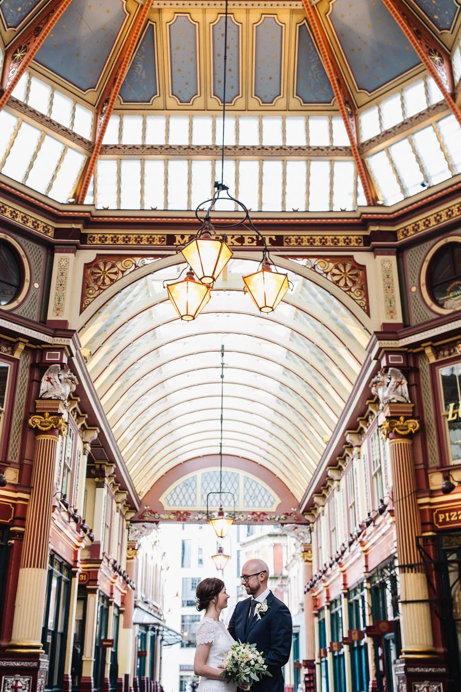 Bride and groom smiling at one another in Leadenhall Market.