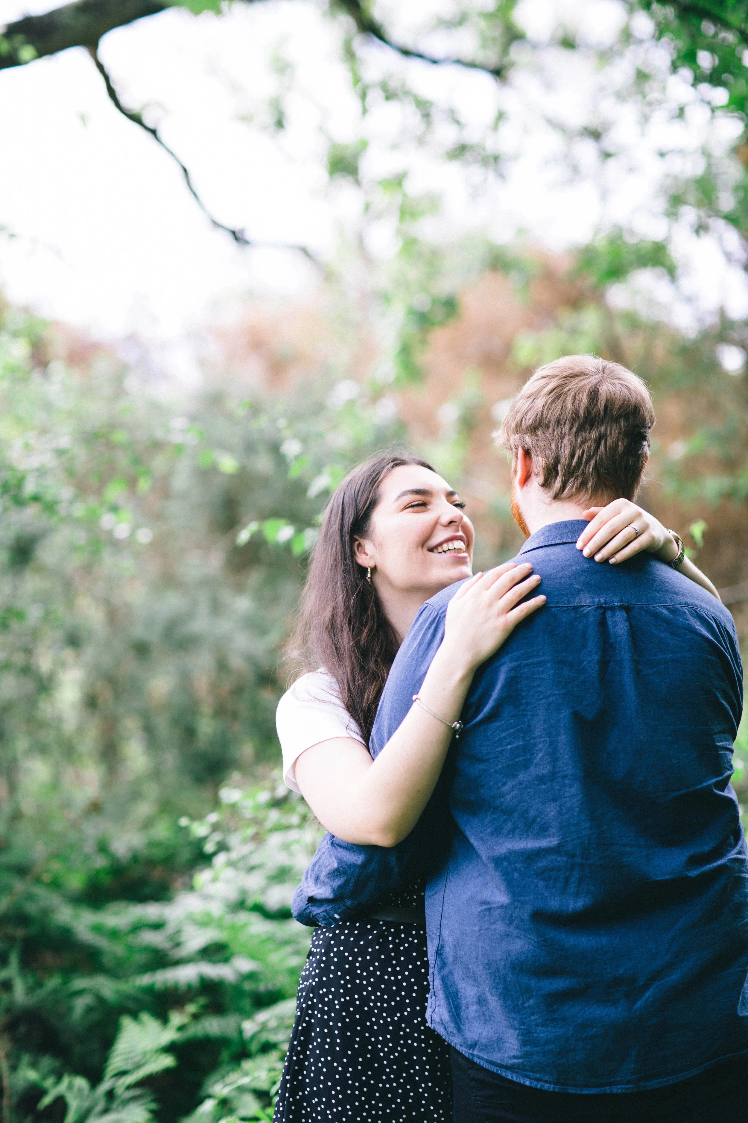 Couple smile at each other during their engagement photography session on Wimbledon Common