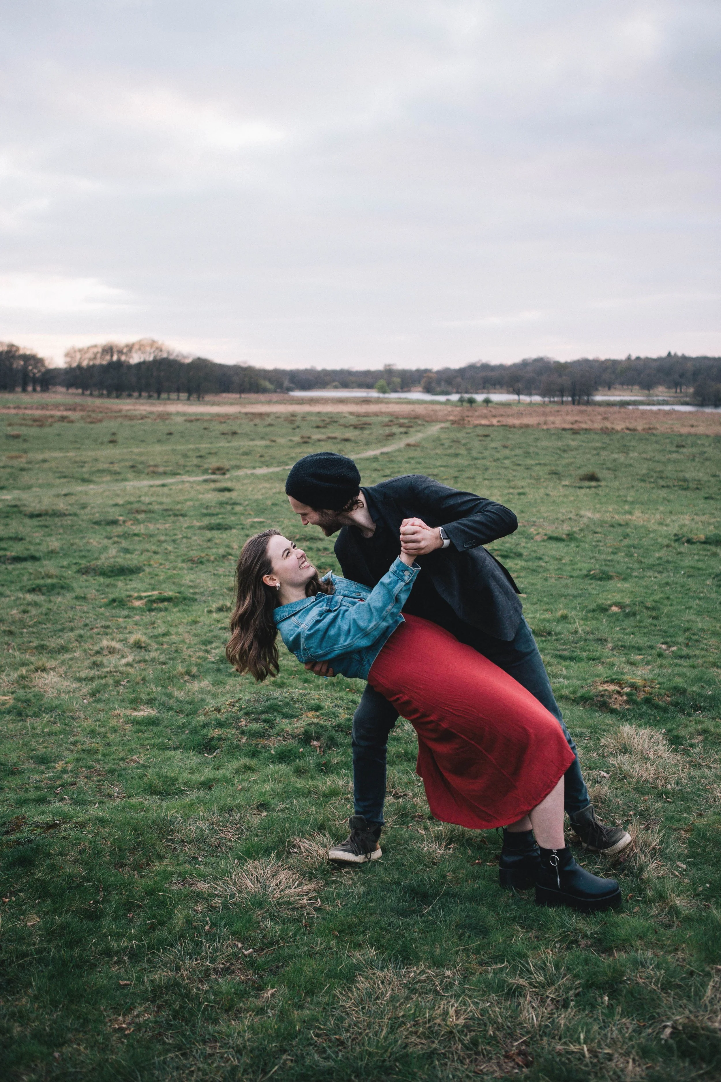 Man dips his fiancée during their engagement photography session in Richmond Park