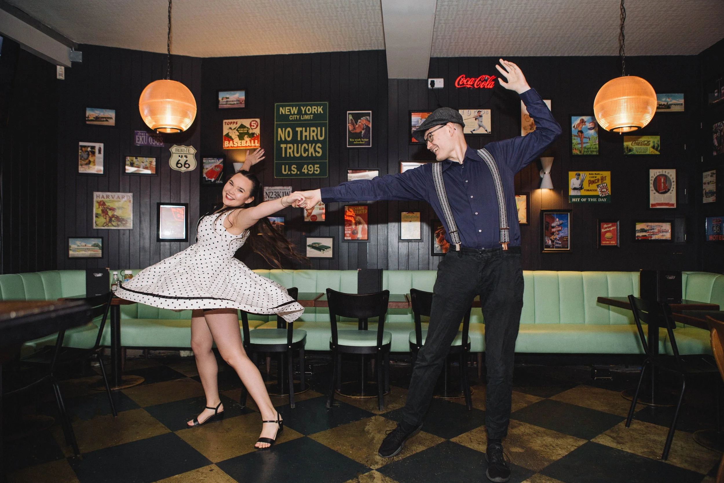 Couple dance during their engagement photography session in an American style diner