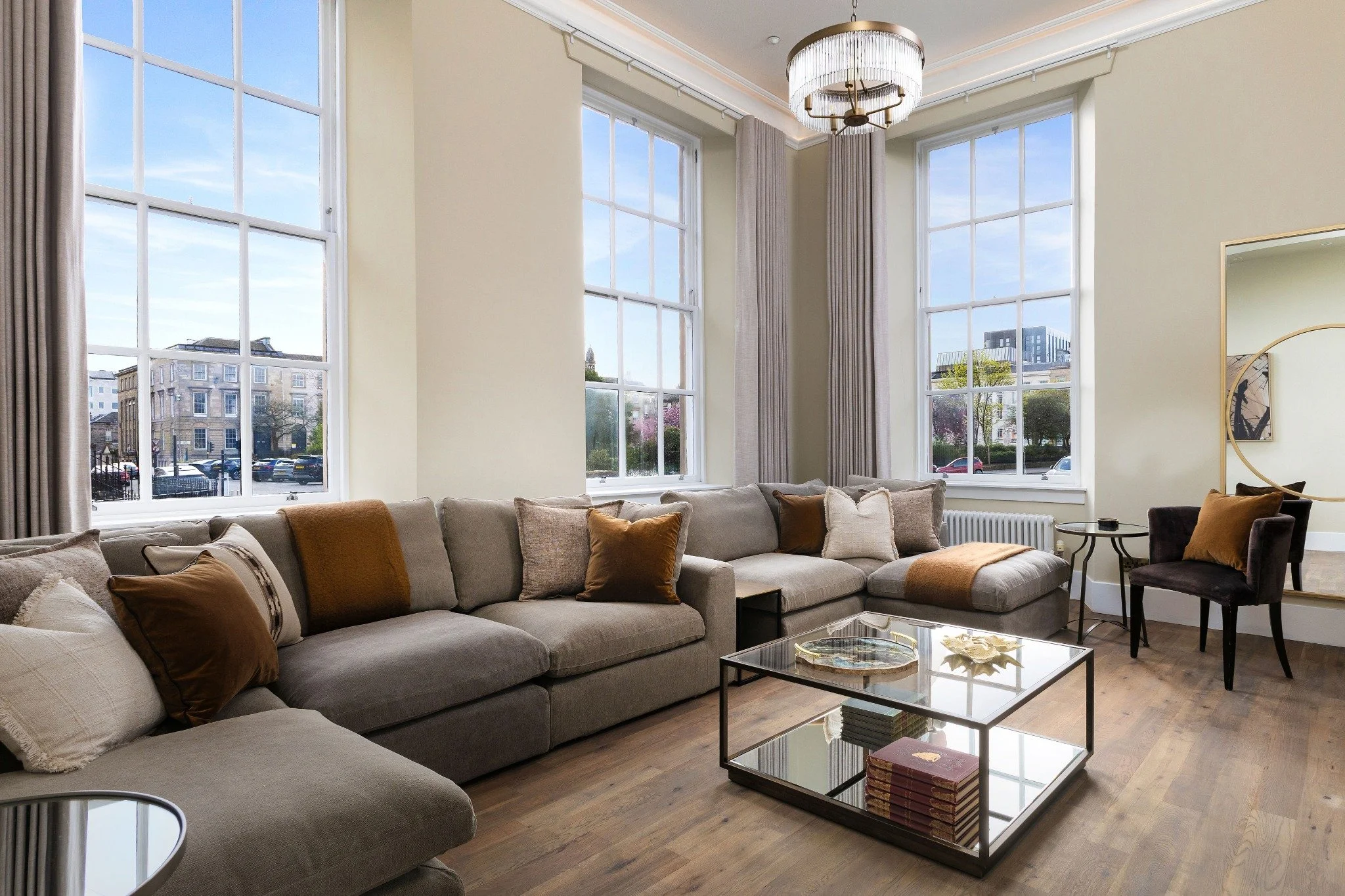 A tall Georgian living room with large sash windows, prepared for guests
