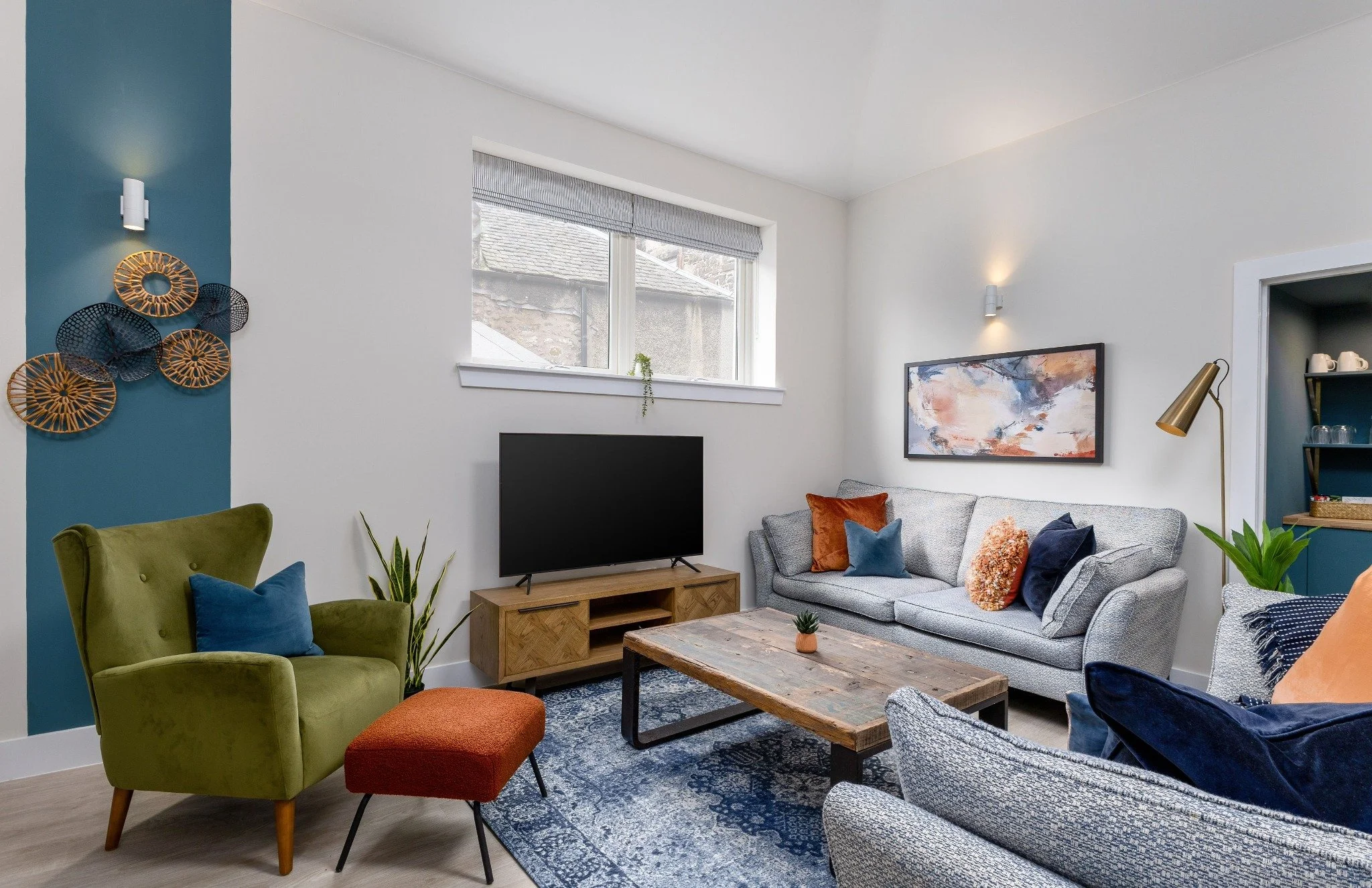 A bright contemporary apartment living room with a green velvet armchair