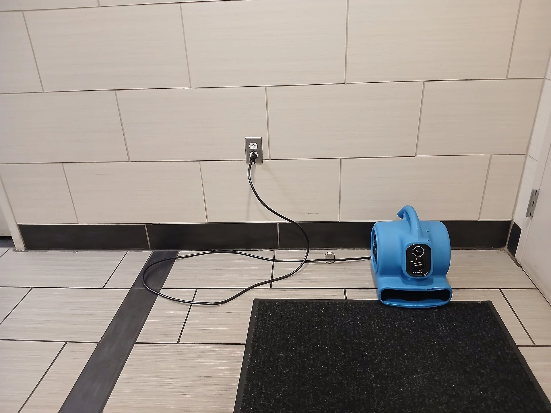 Air mover drying a water-damaged floor