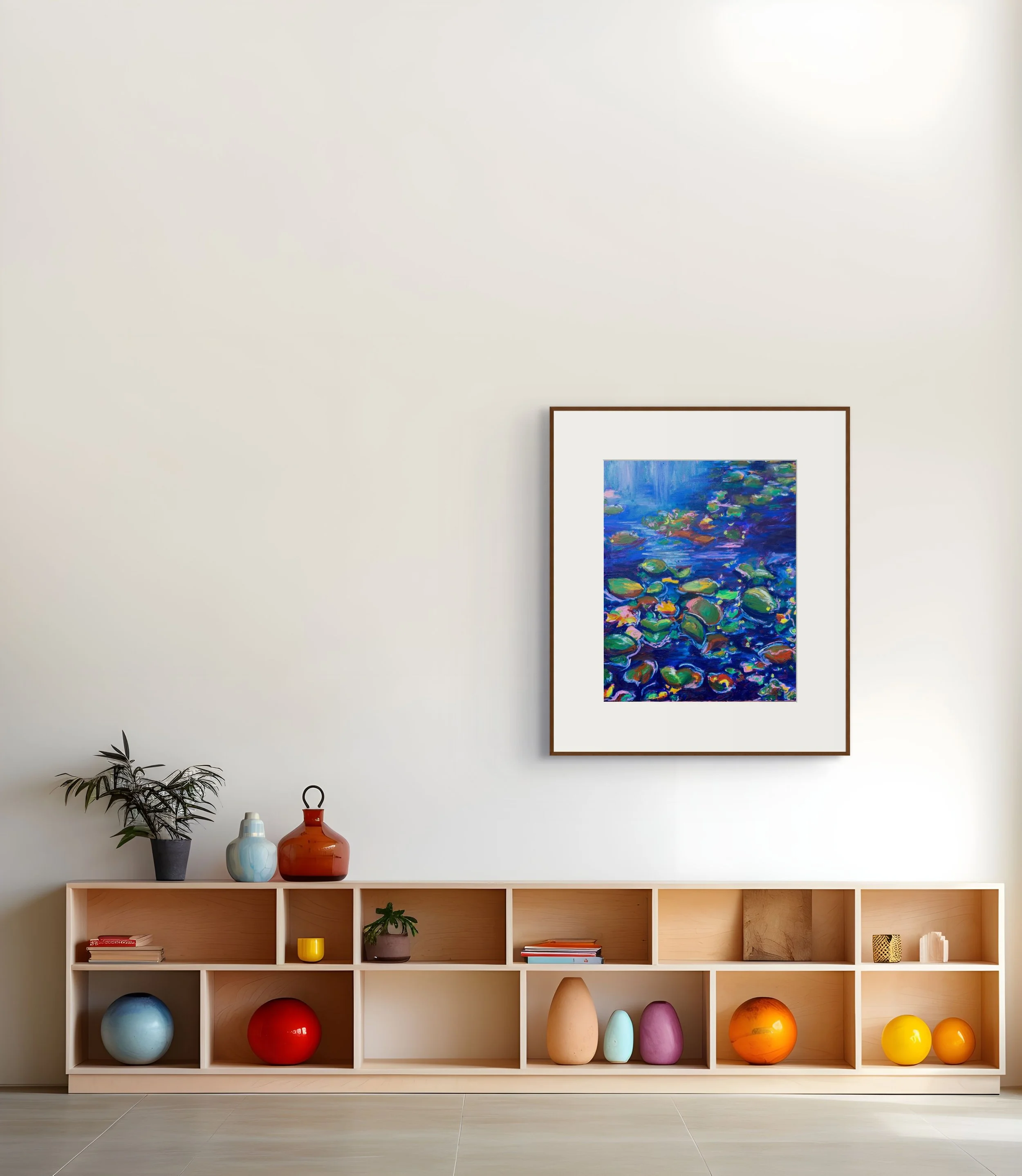 Bright modern living room with framed colorful lotus pond artwork, a potted plant, decorative vases, and open wooden shelving filled with books and colorful objects.
