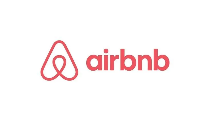 Airbnb logo with red icon and text on white background.