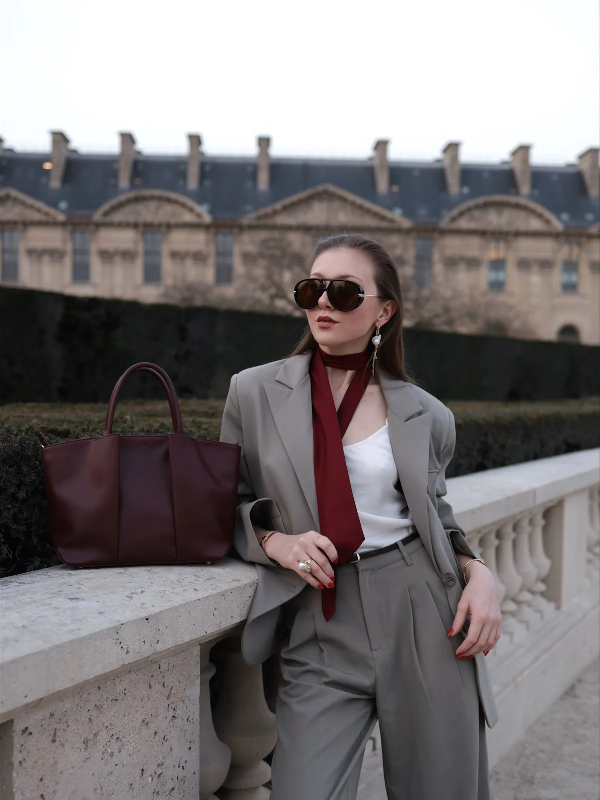 Emily Varr with a burgundy KAAI bag at the Tuileries, Paris Fashion Week