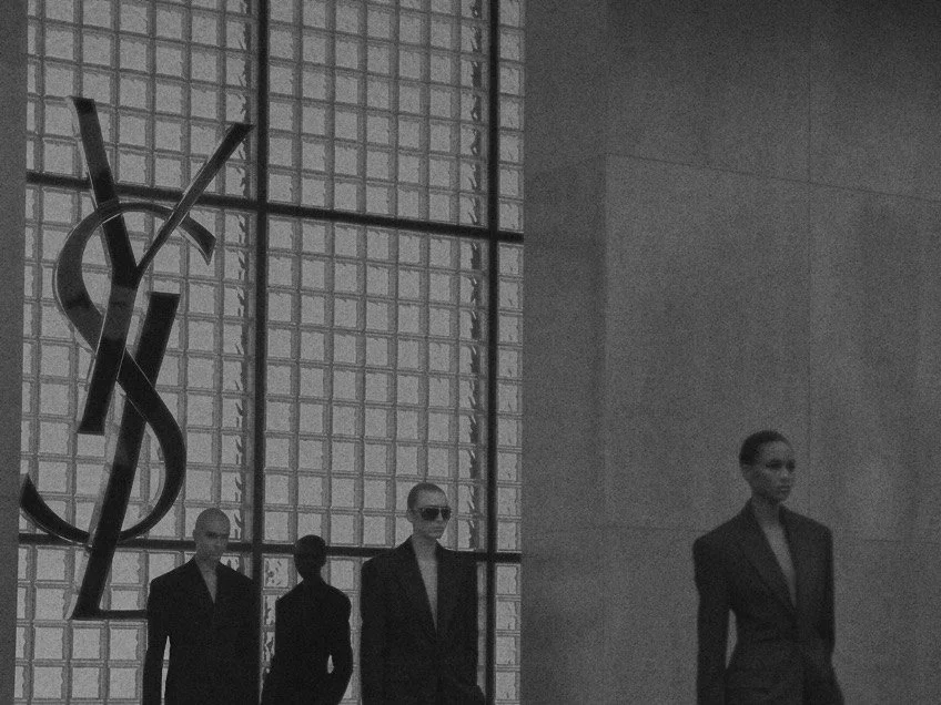 Saint Laurent show at Paris Fashion Week, models in black suits by the YSL logo