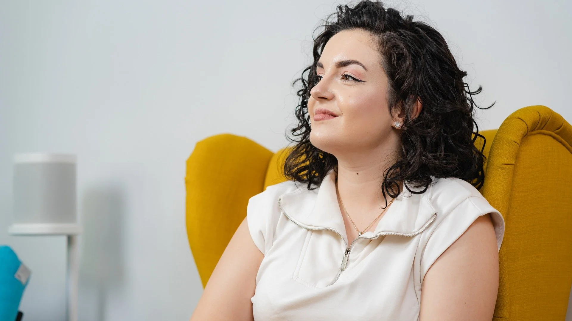 Bianca Ceruța seated in a mustard armchair during a conversation.