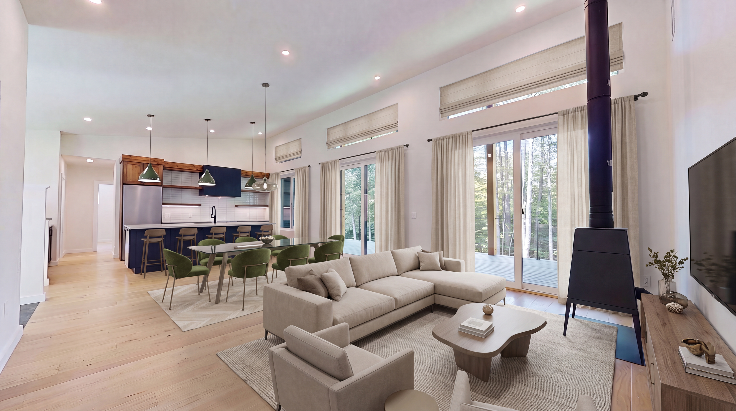 Modern open-concept living room and kitchen with fireplace, sectional sofa, dining table, and floor-to-ceiling windows overlooking trees