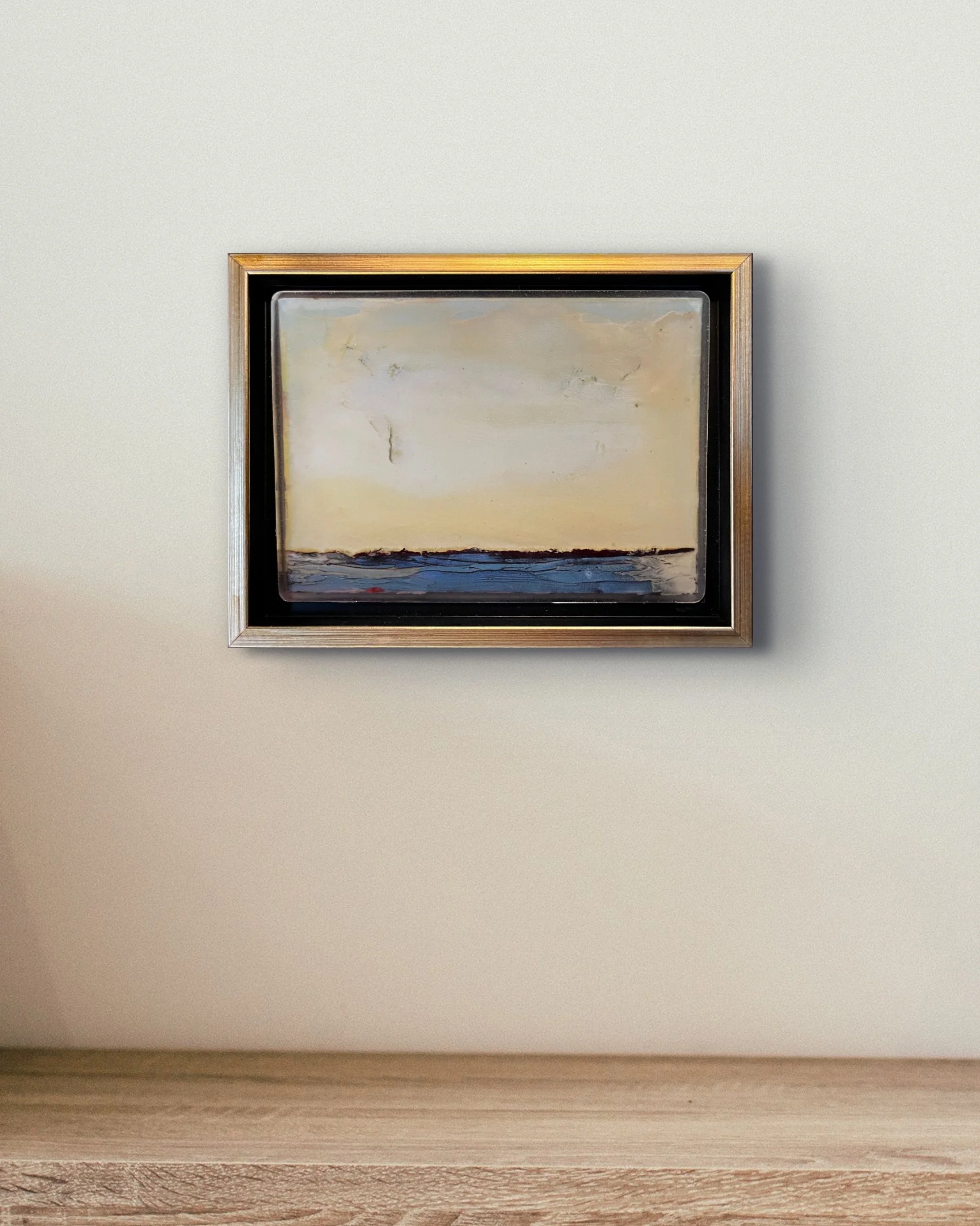 In situ installation view of No. 663 (Winter 2024) by Danny Perkins, a 6.5x8.5 inch oil on board with resin in a gold float frame featuring a pale cream cloudscape over a blue horizon
