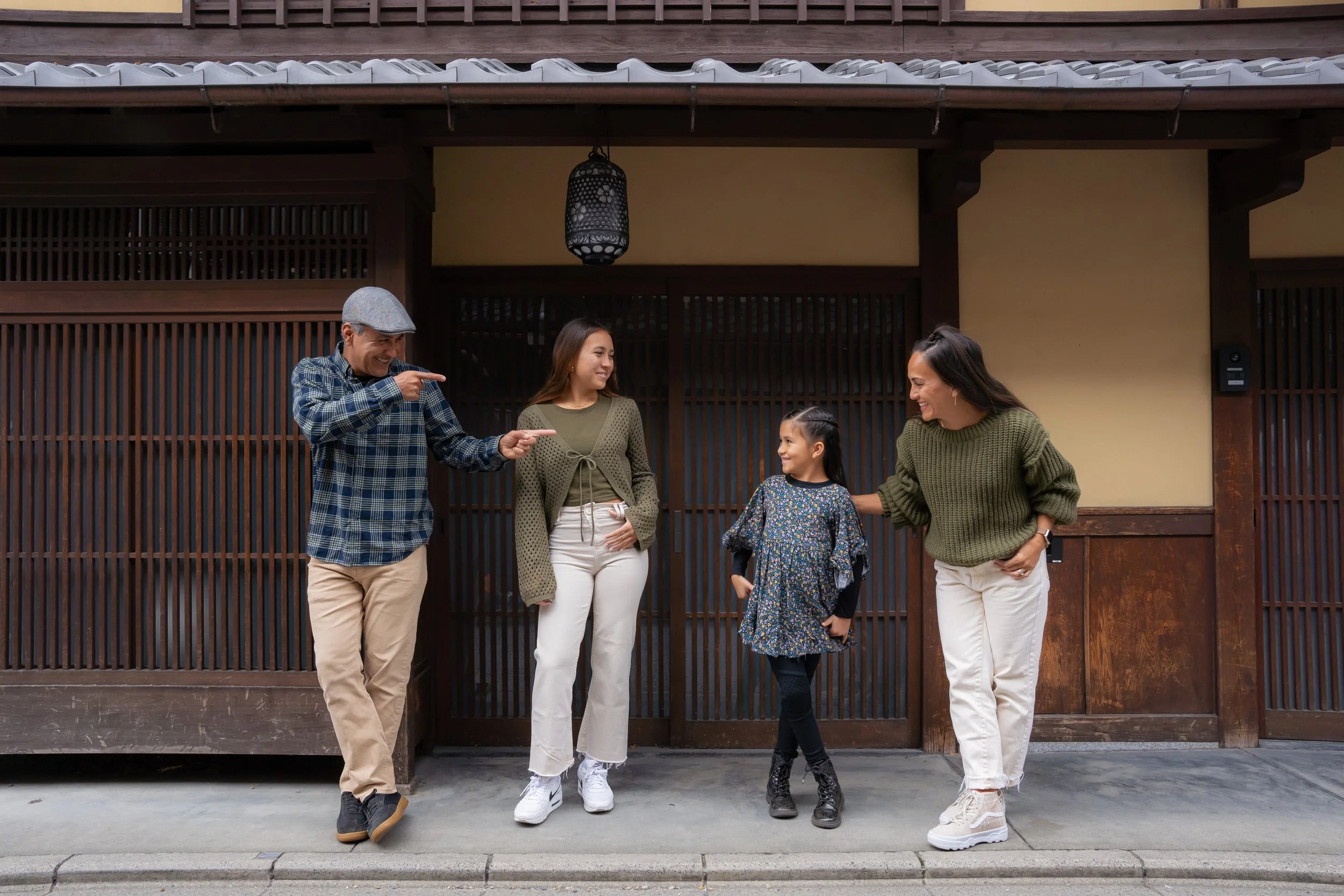 Photographer J. Anthony Martinez, on the left, with his family outside a traditional wooden building in Japan.
