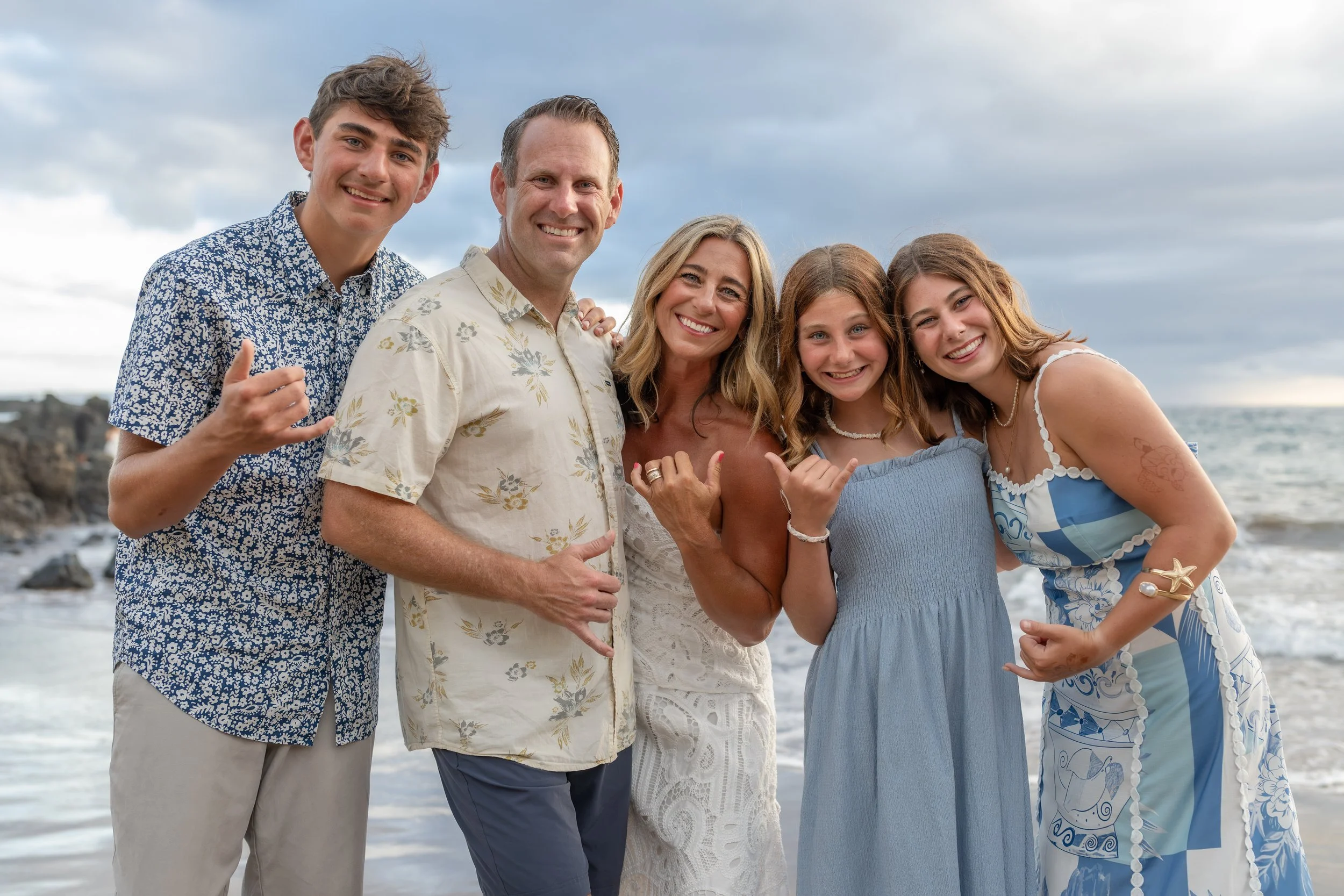 Smiling family gathered together for a close-up beach portrait.